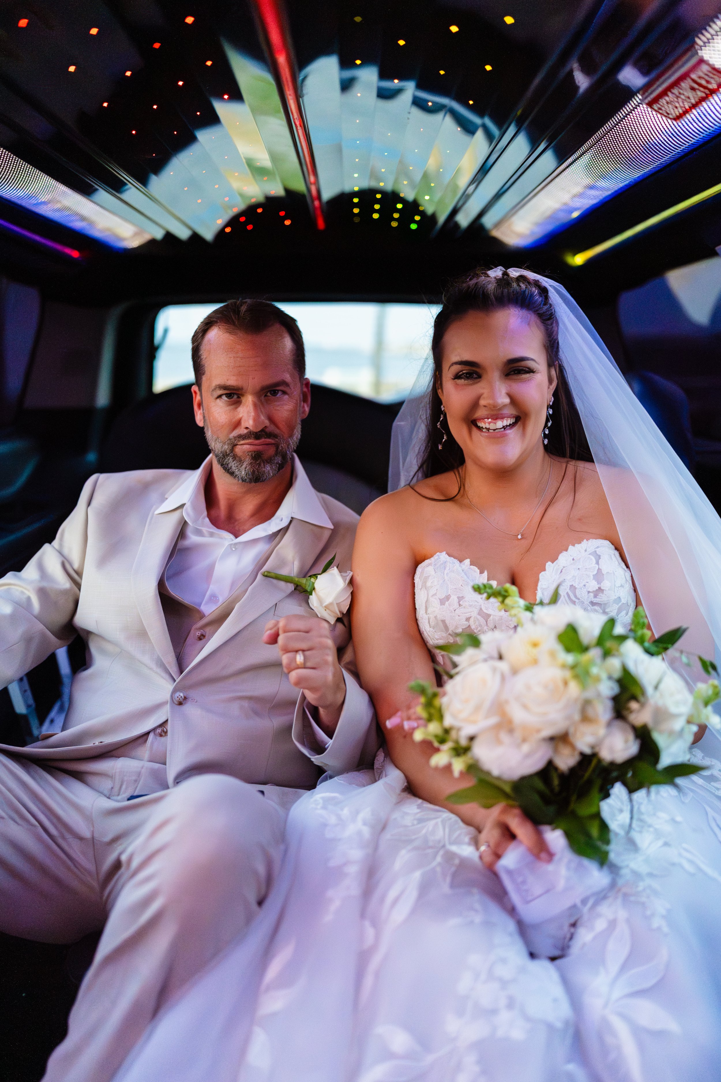 Bride and Groom looking at camera in limo after wedding ceremony in Ocean Gate, New Jersey. 