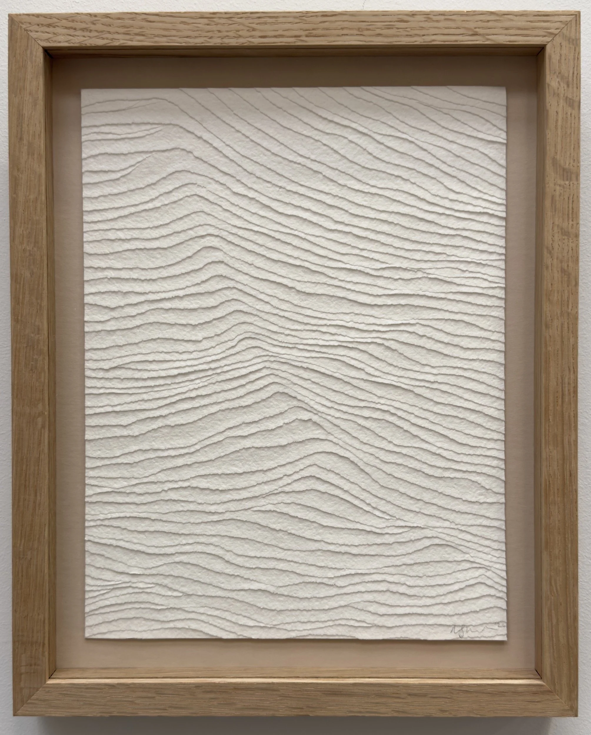 white textural artwork of gentle waves in the sea. Framed in oak.