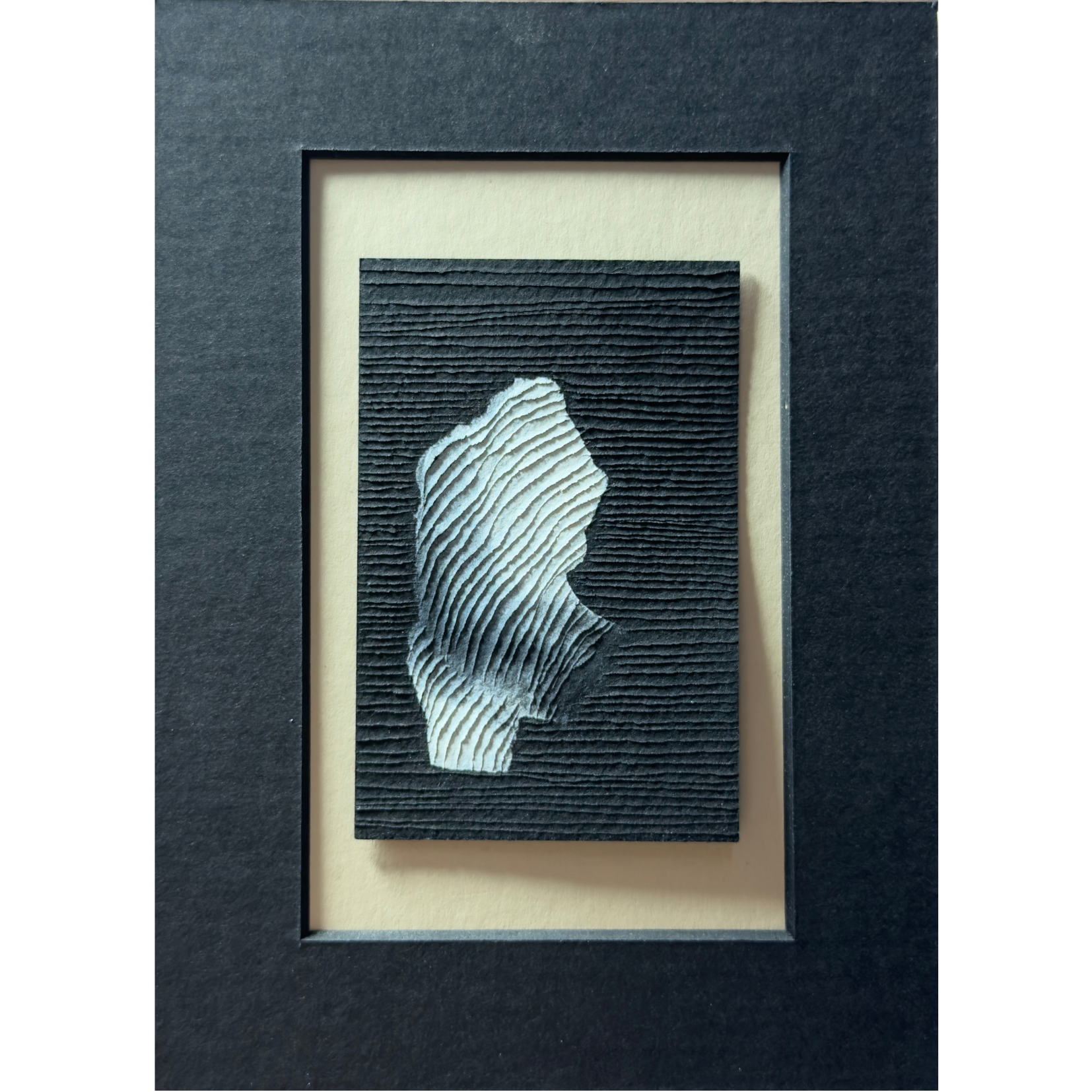 small abstract white painting on black paper with textural carvings with black window mount