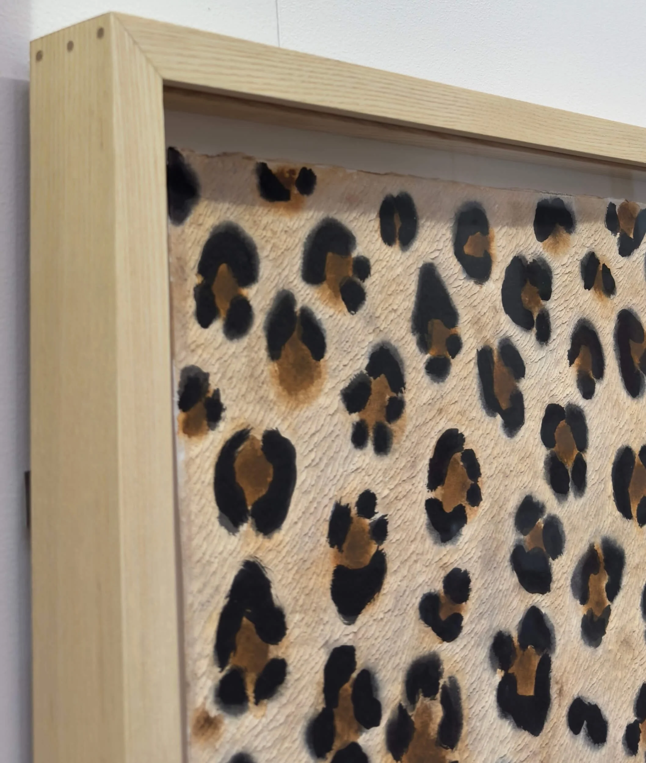 corner detail of bespoke ash frame with leopard print textured artwork
