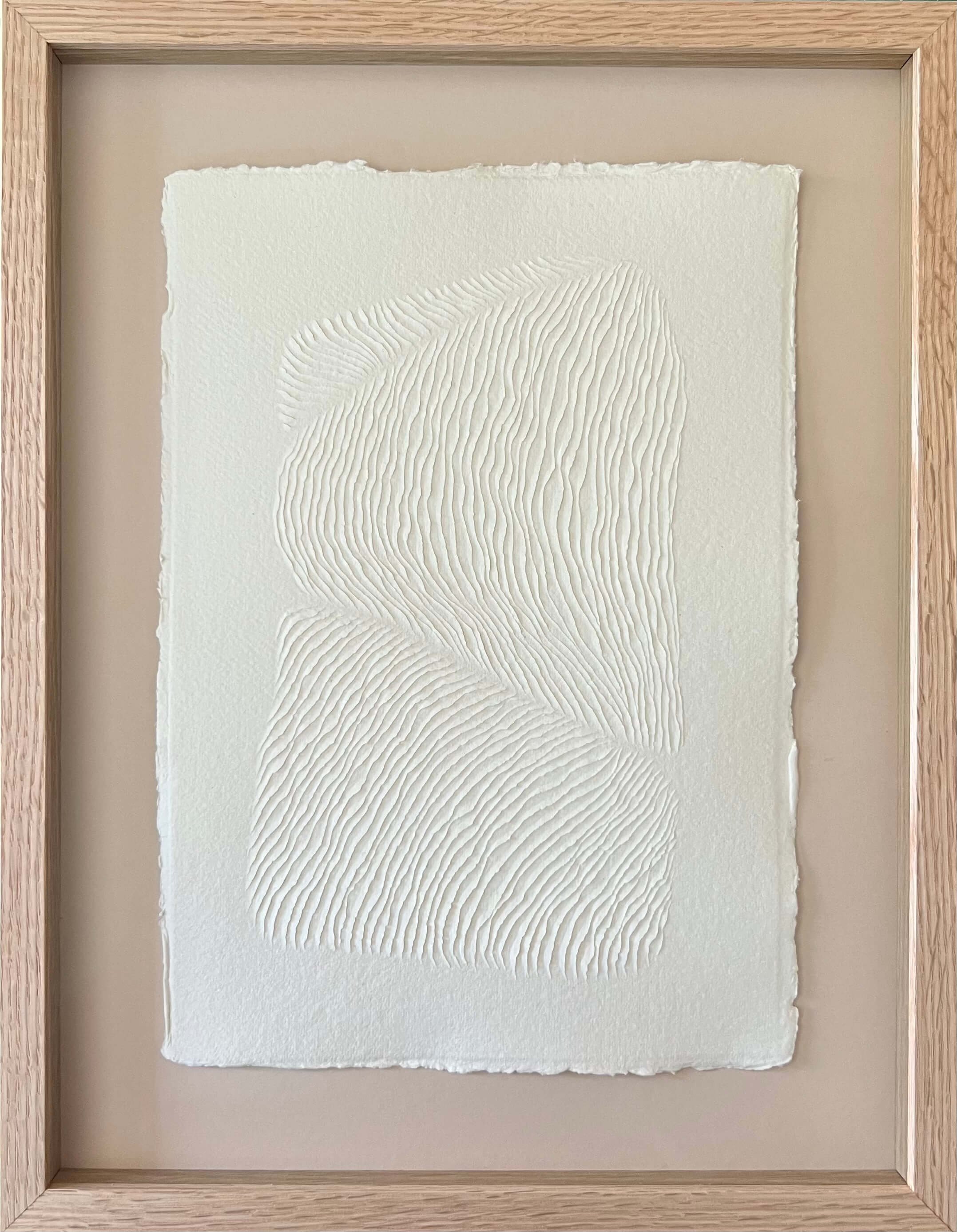 A4 size all white artwork with a 3D textured surface that's carved into the surface creating an image flowing across the paper. Framed in oak with artless