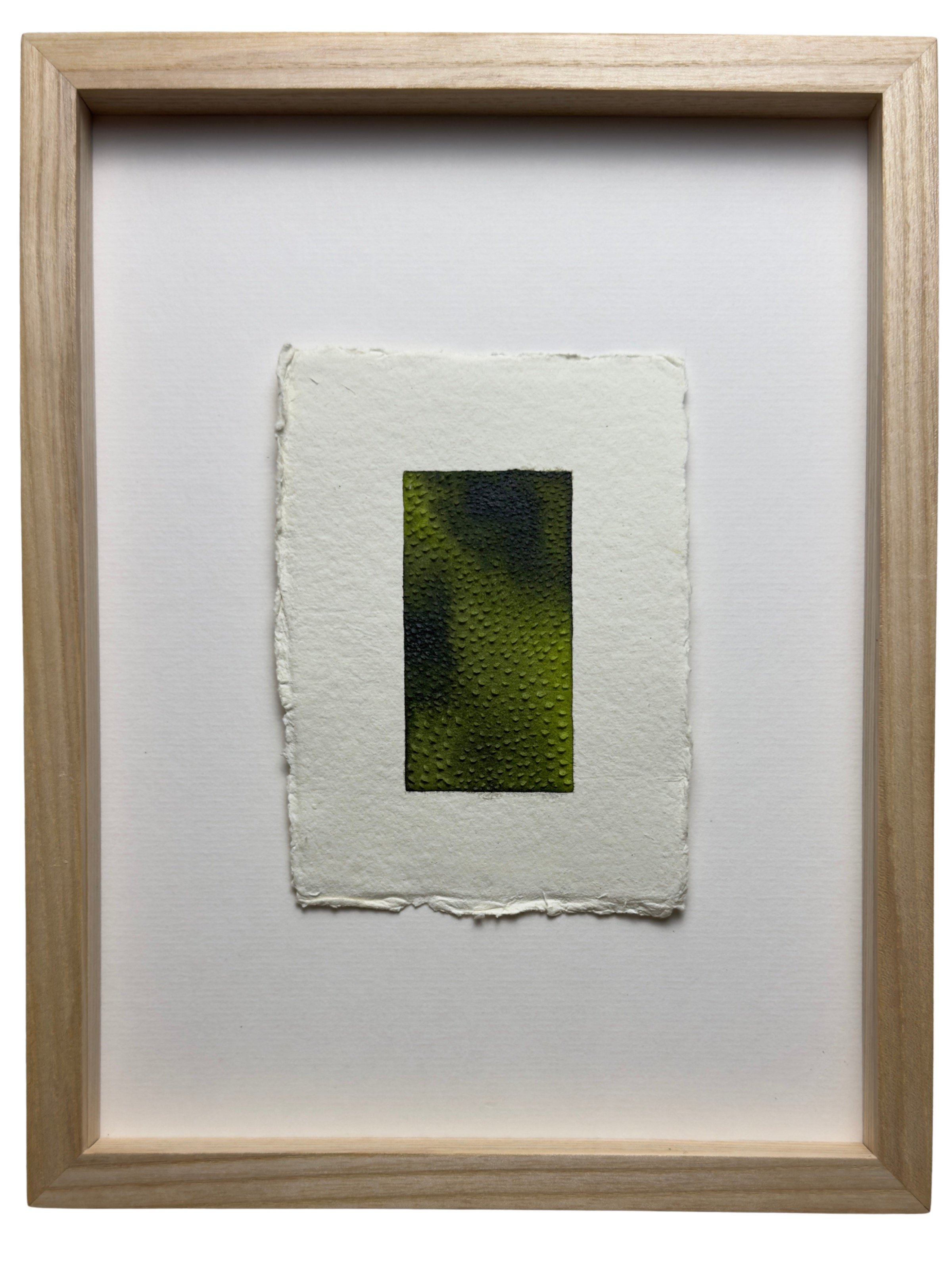 small green painting with dimple carvings on white paper, framed in oak