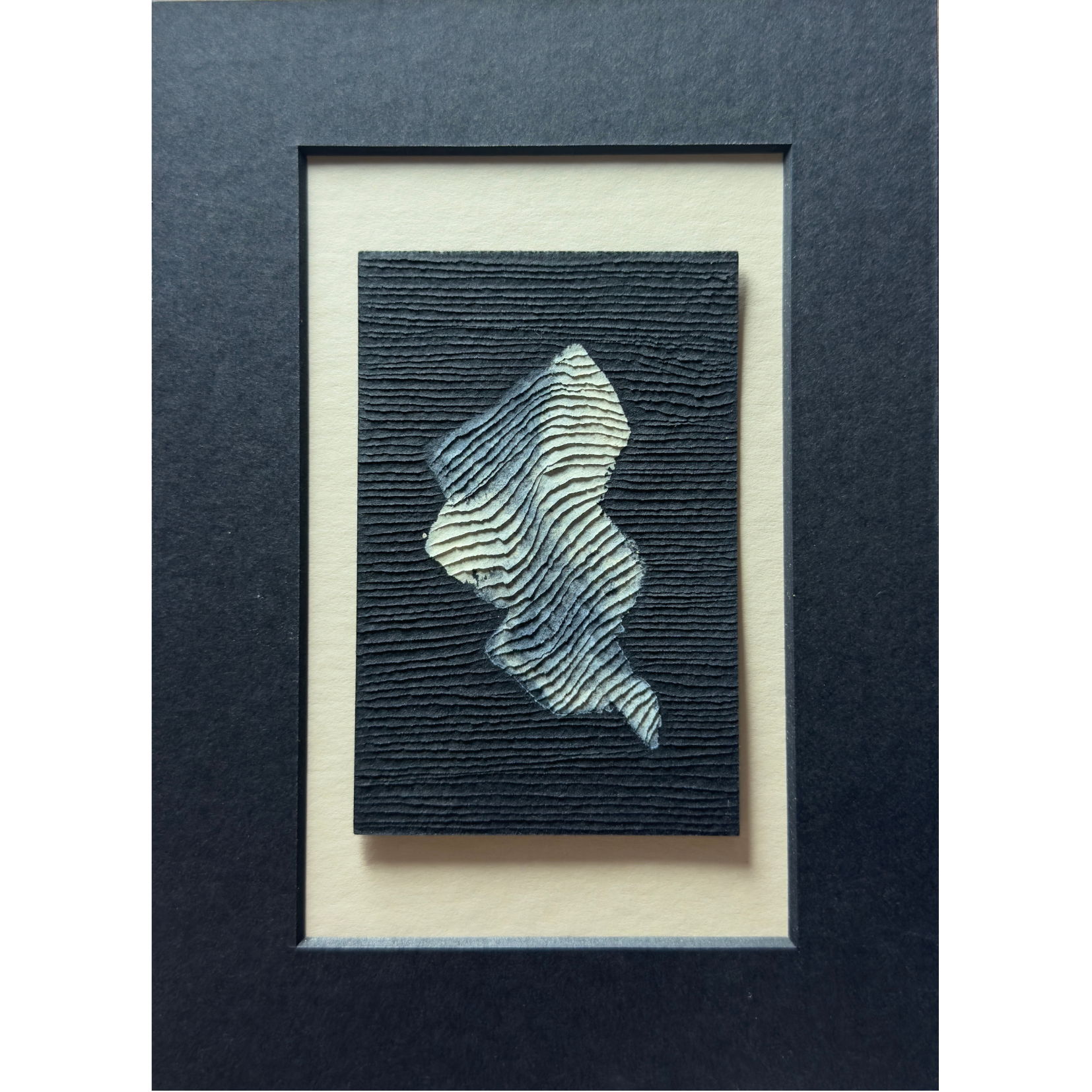 small abstract white painting on black paper with textural carvings
