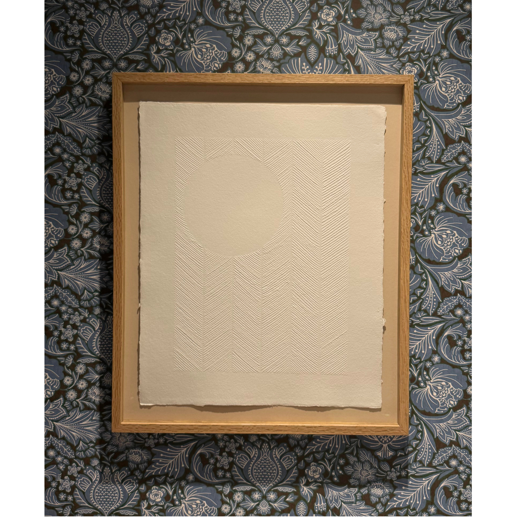 styled photo of textured white artwork on paper with carvings. The full moon in the sky with chevron pattern