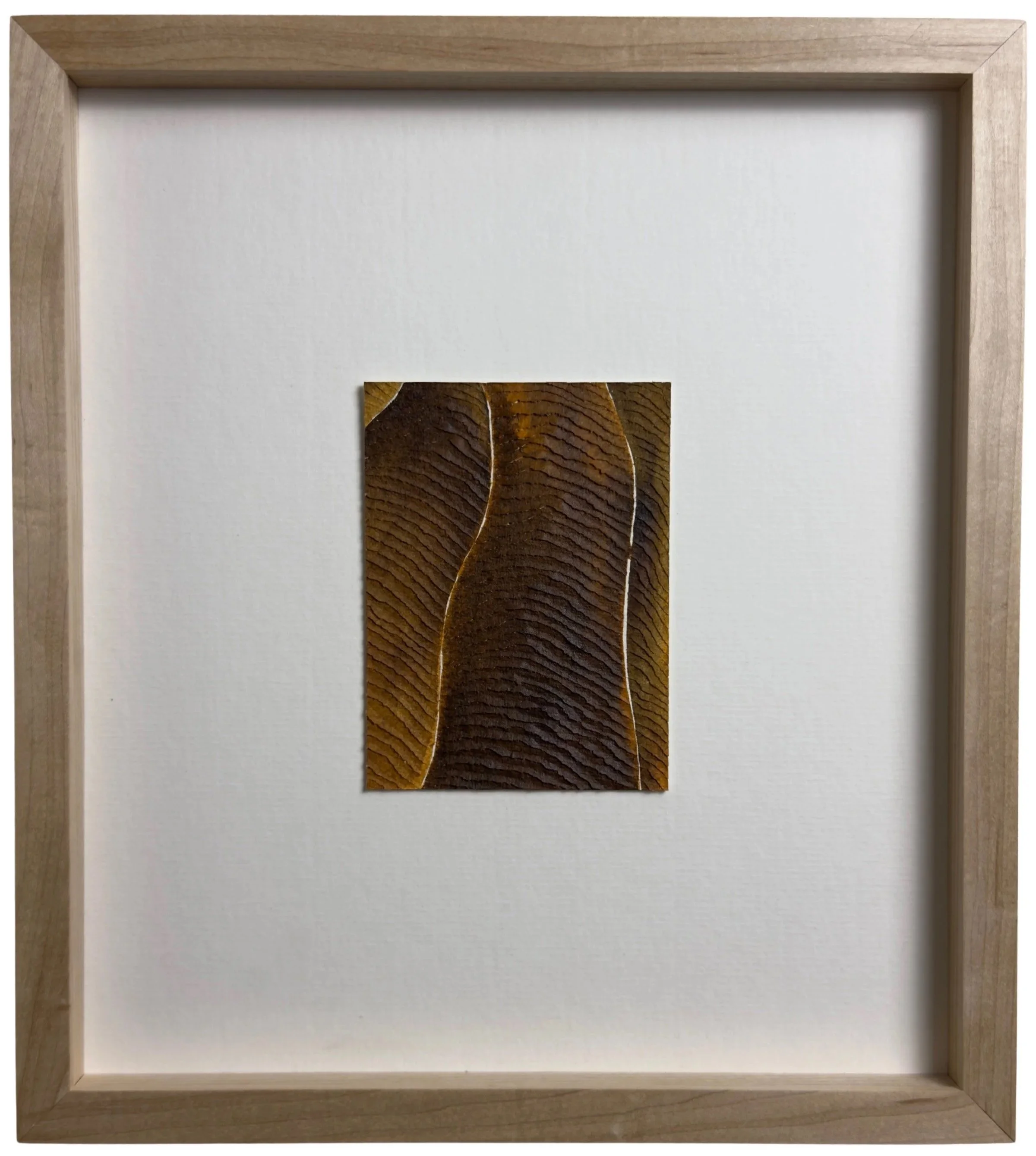Small brown artwork with textured carvings on paper with a wide mount, framed in ash wood
