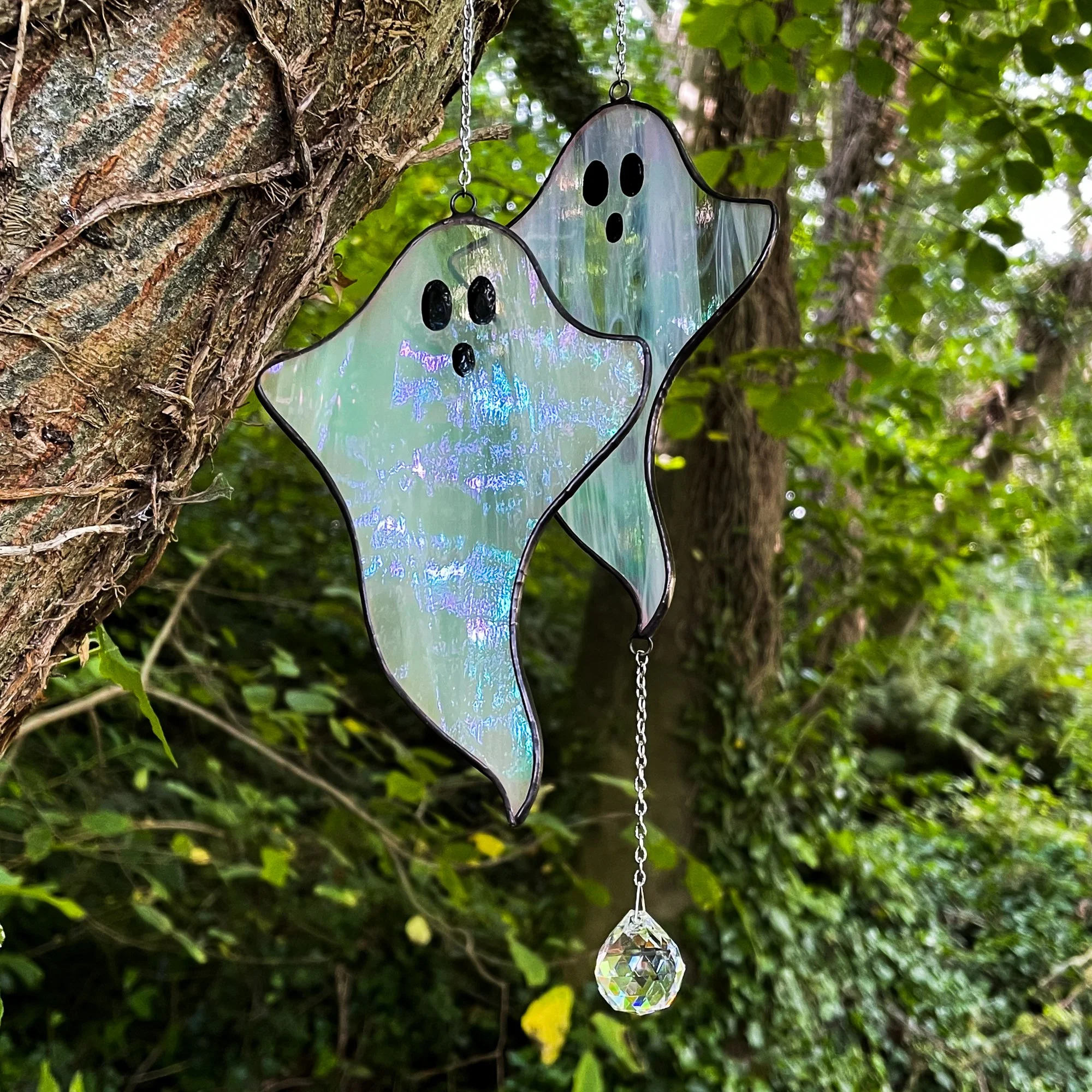 two stained glass ghosts in a woodland setting