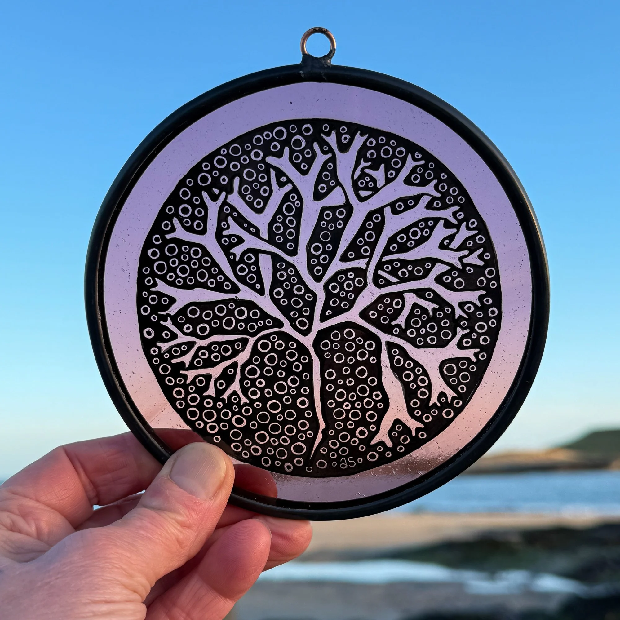 Stained glass Irish seaweed rondel photographed at the beach that inspired the work.