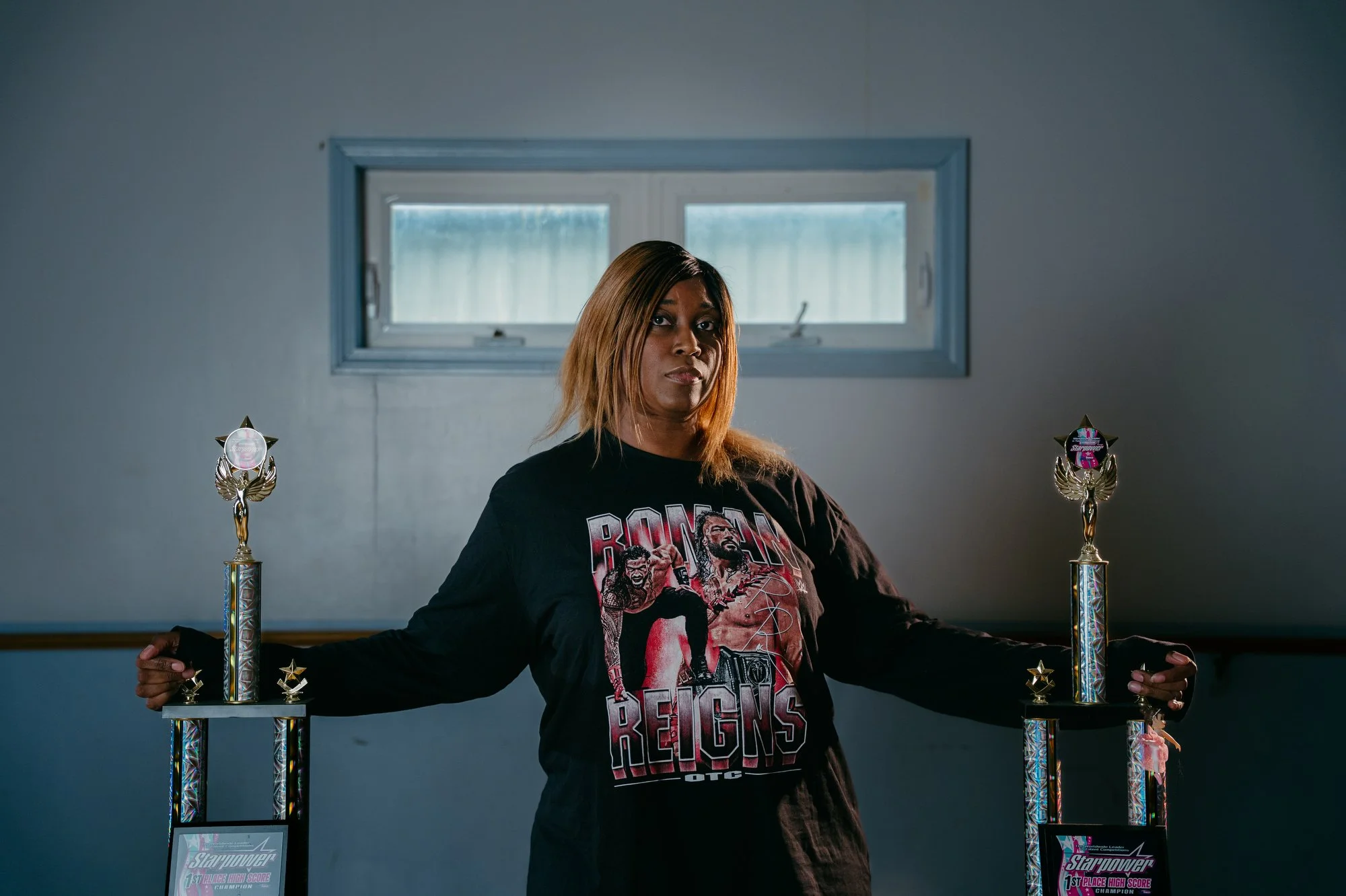 Raina Tanner, cancer survivor, long-time WWE fan and dance teacher, poses for a portrait with some of the trophies her dance students at True Diversity Dance Team have won at her dance studio in Warren, Ohio on June 22, 2026. Tanner is one of three f