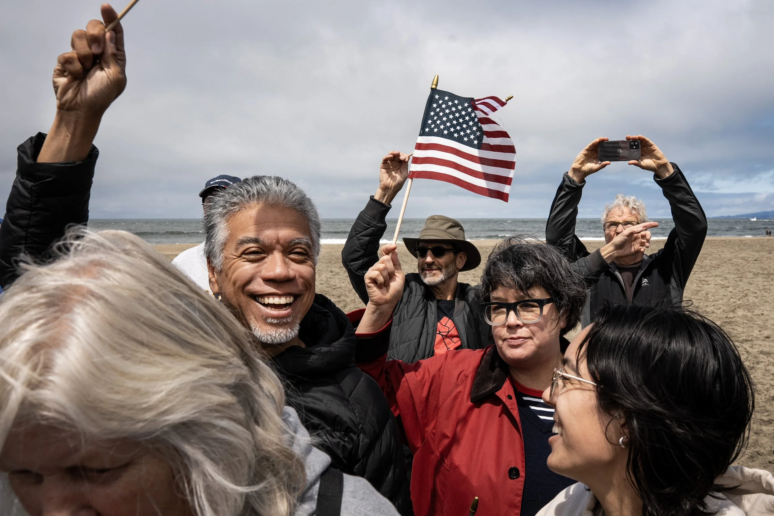 Protesters sing and dance to “We are Family” by Sister Sledge during an action hosted by Families First at Ocean Beach in San Francisco, Calif. on Saturday, July 26, 2025. The protest was held to voice concerns over cuts to federal programs including