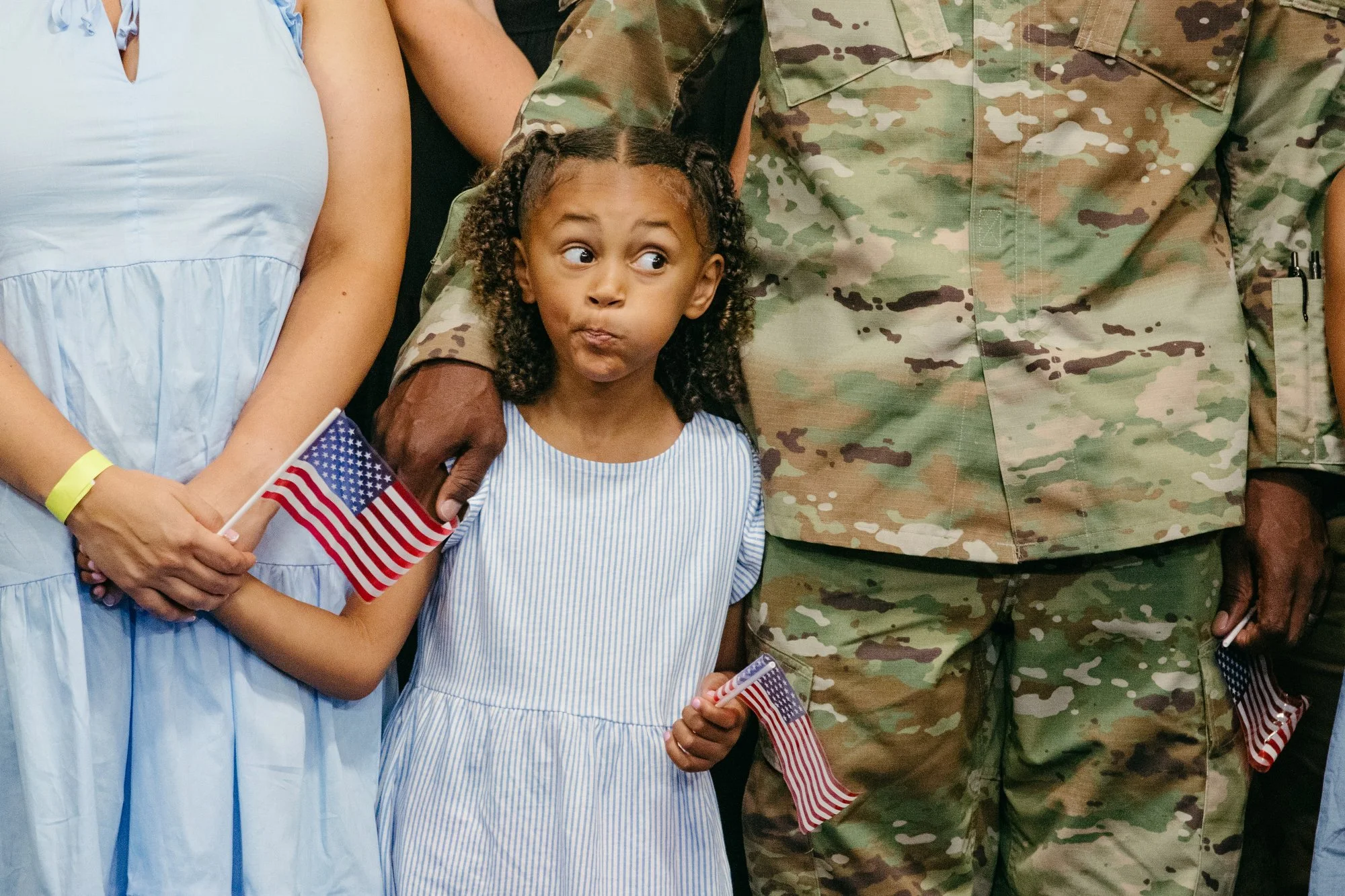 A young girl makes a face to entertain herself as she waits onstage with her parents for President Joe Biden and First Lady Jill Biden to speak at an event in support of Joining Forces at Fort Liberty in Fayetteville, N.C. on Friday, June 9, 2023. Fa