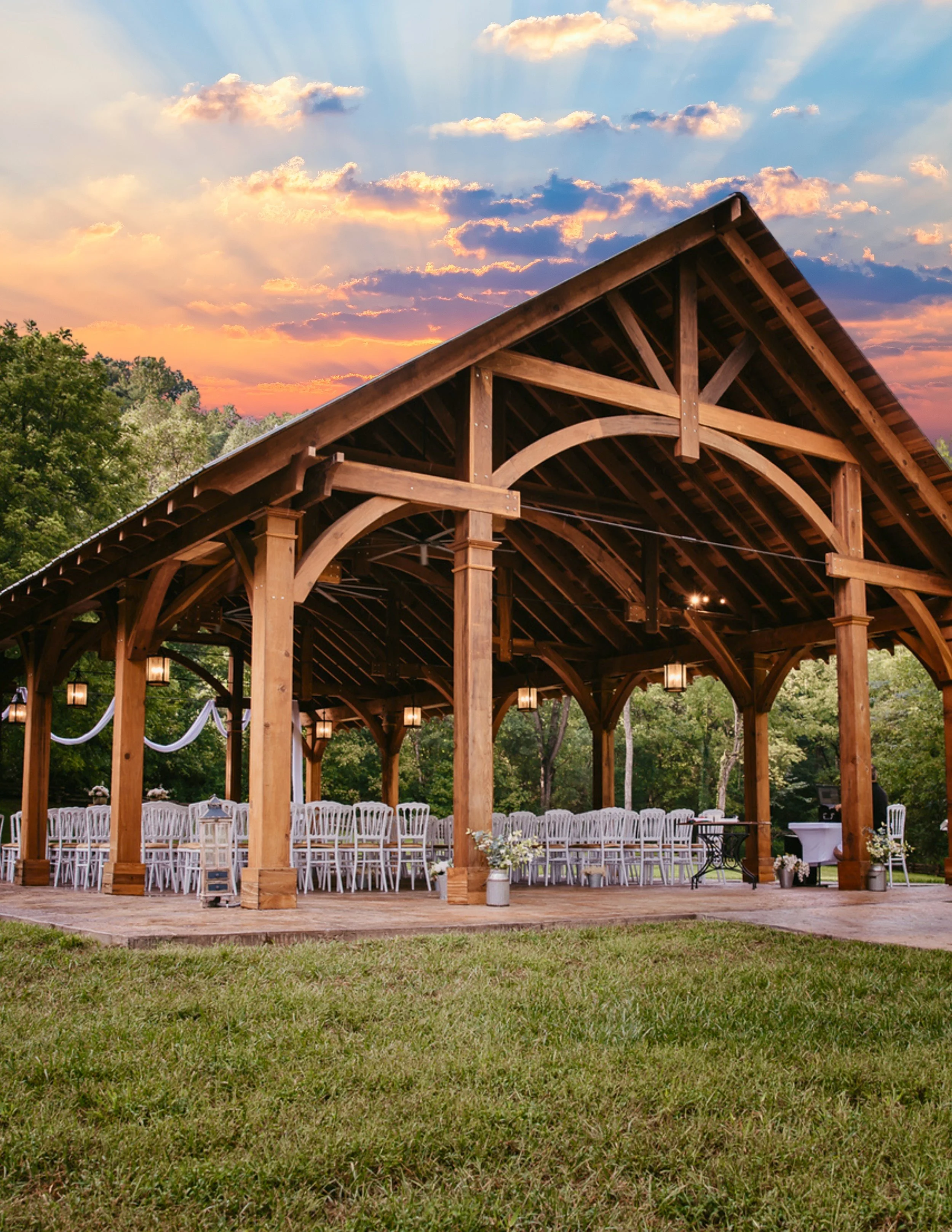 Open-air Smoky Mountain wedding venue pavilion at Leather Bound Hollow in Sevierville Tennessee with ceremony seating and sunset skies.
