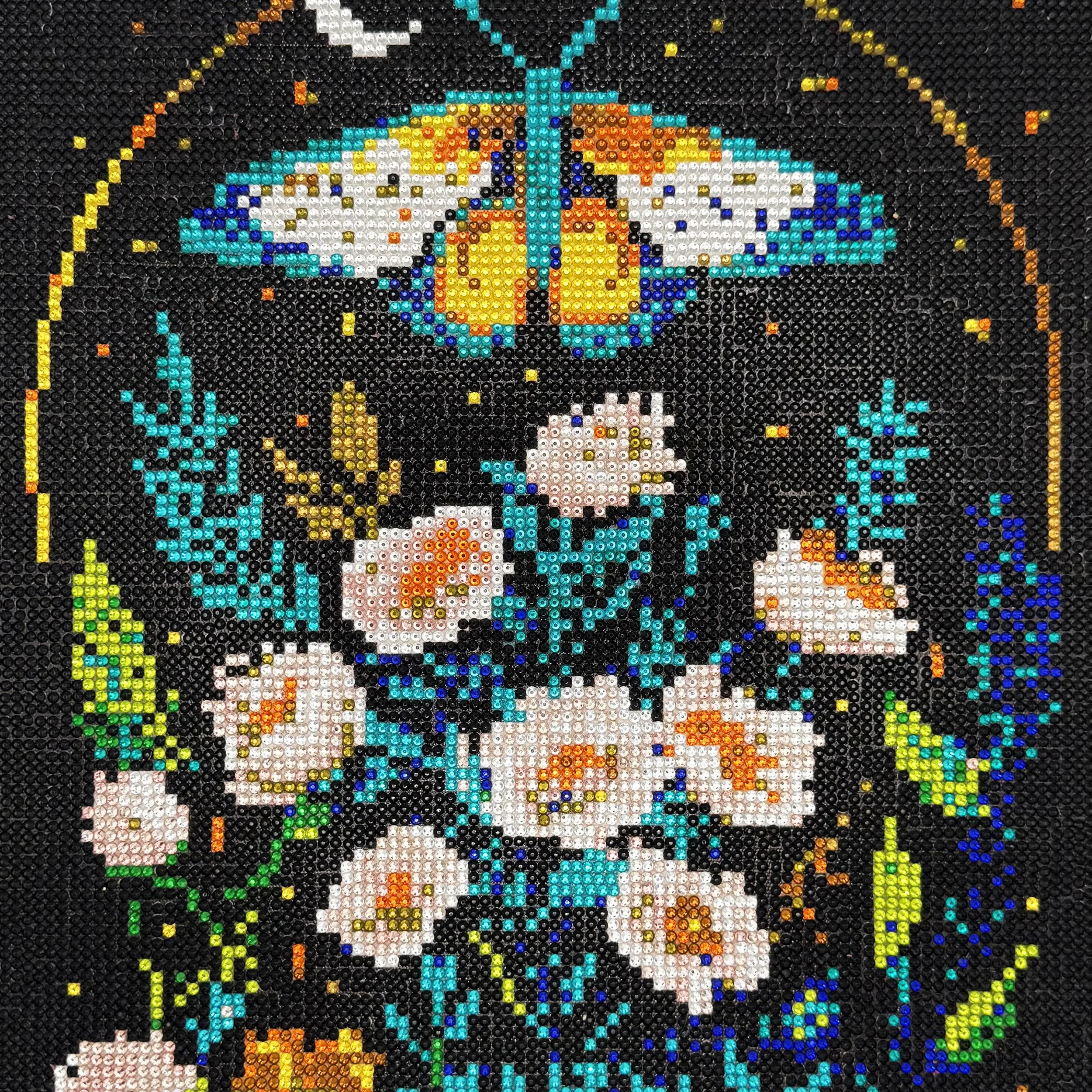 Beaded artwork of a skull surrounded by flowers, leaves, a large butterfly, and birds, all created with colorful tiny beads.