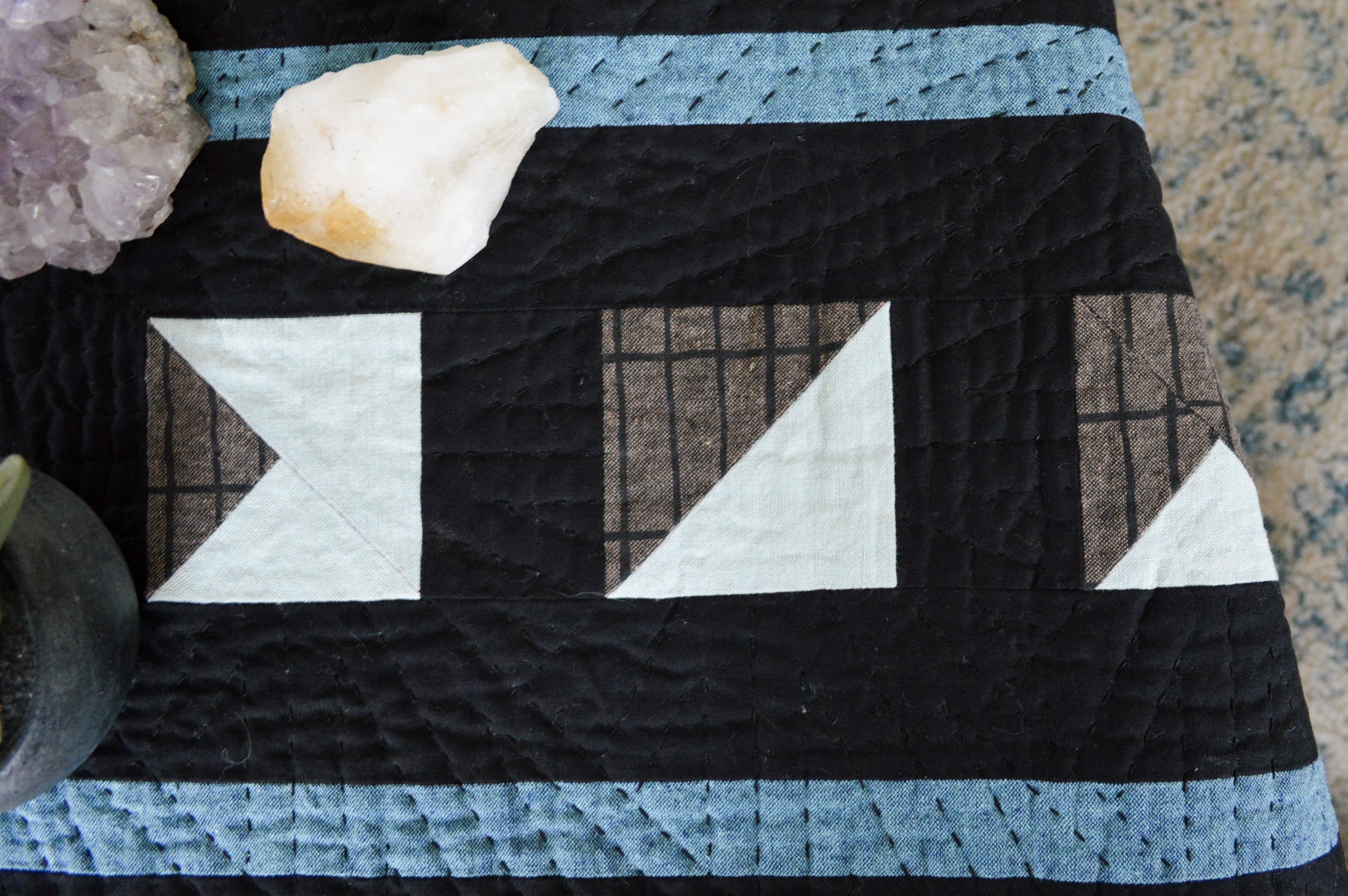  close up of a quilted table runner with a geometric design inspired by the moon 