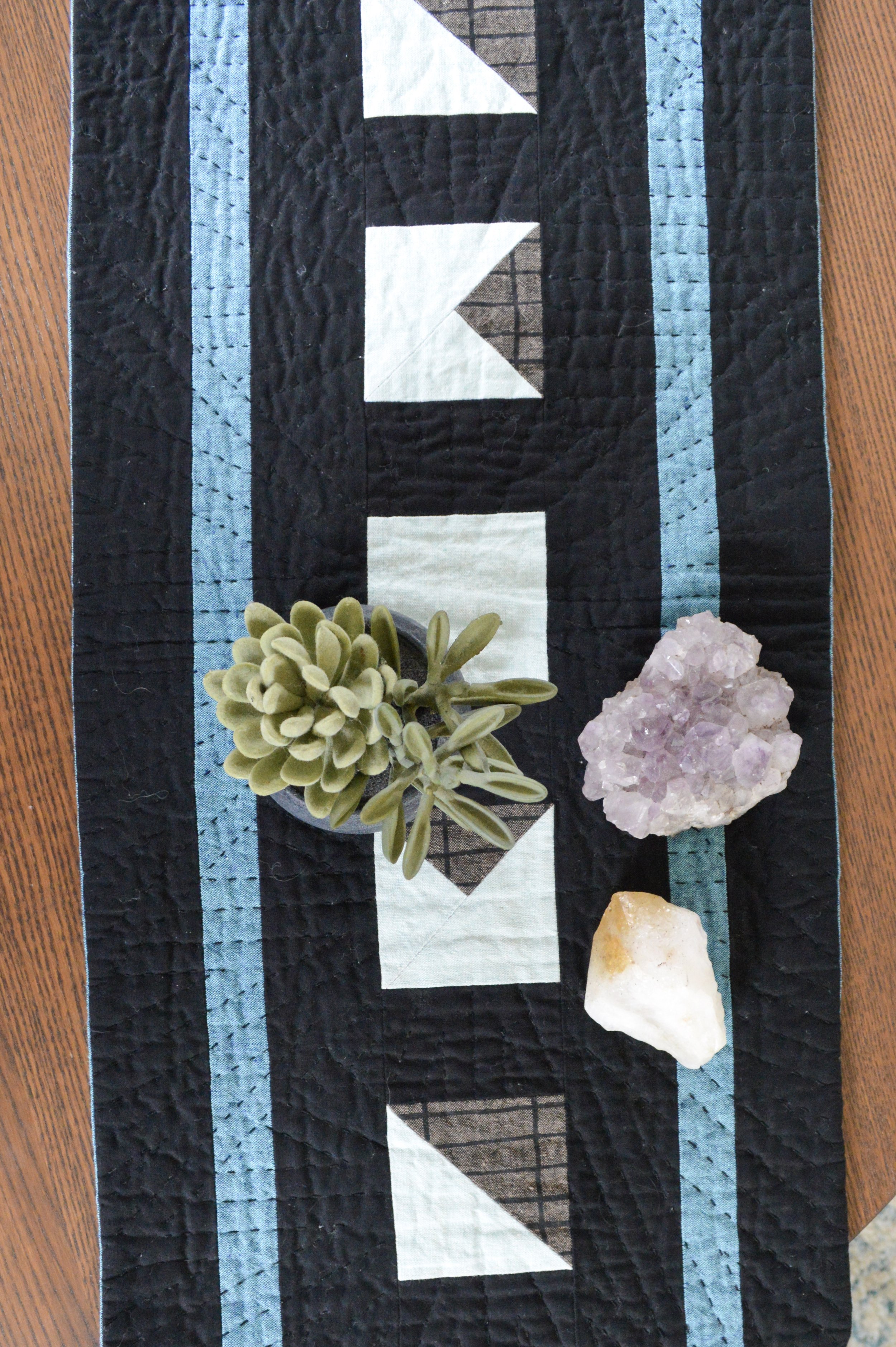  close up of a mini quilt with a geometric design inspired by the moon 