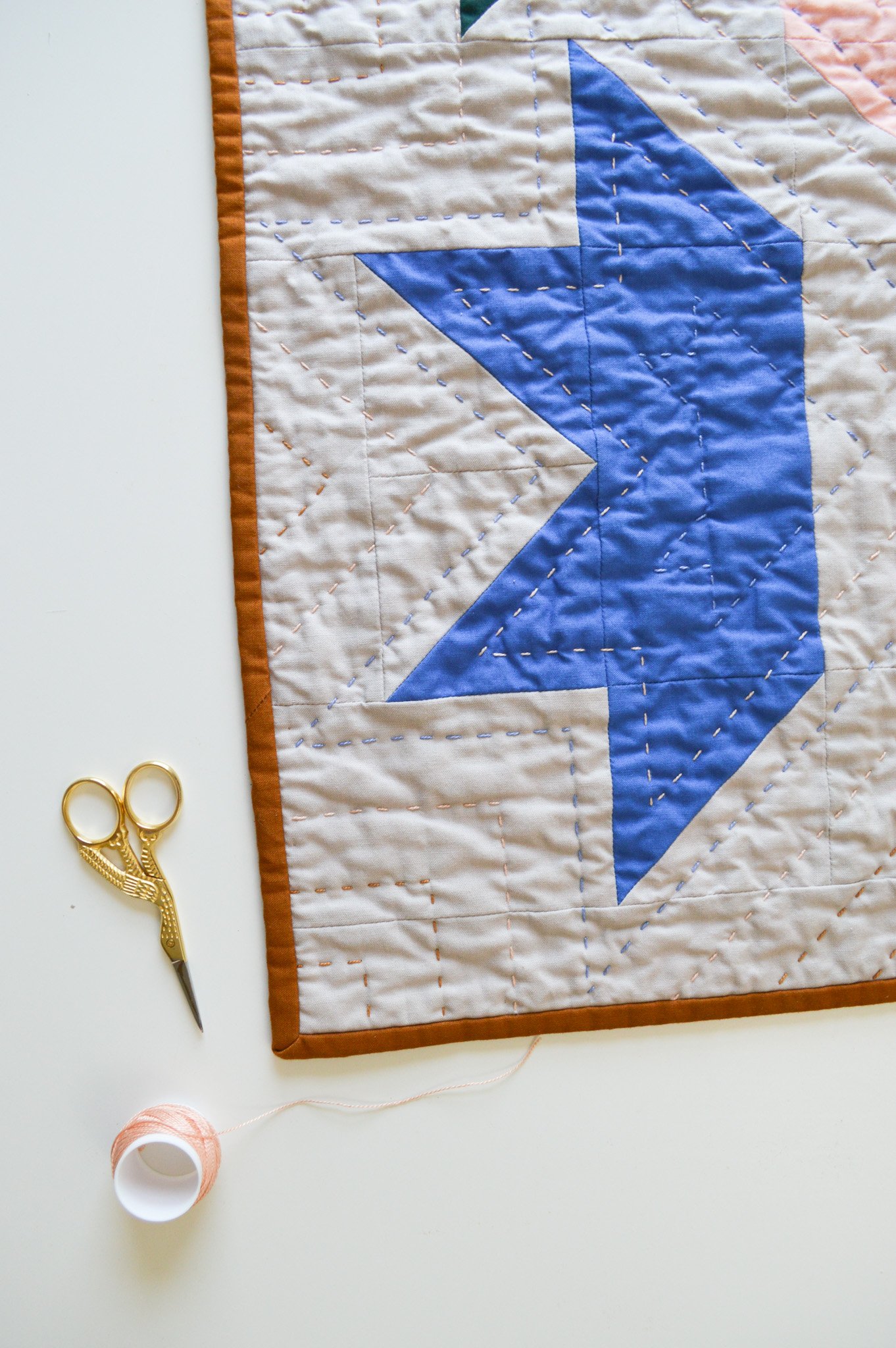  a hand-quilted mini quilt with a blue star design 