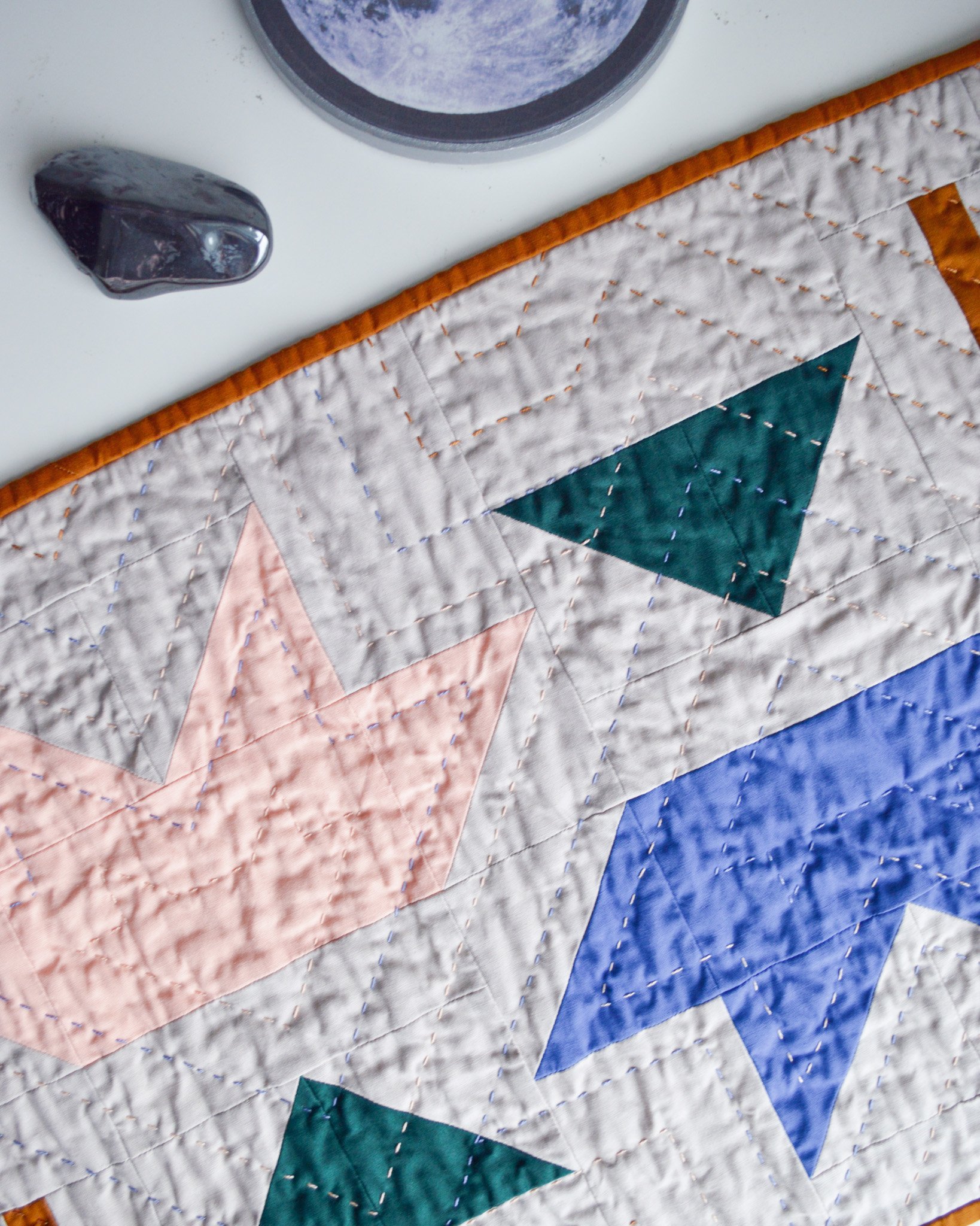  a hand quilted mini quilt, the texture and crinkly and casting shadows 