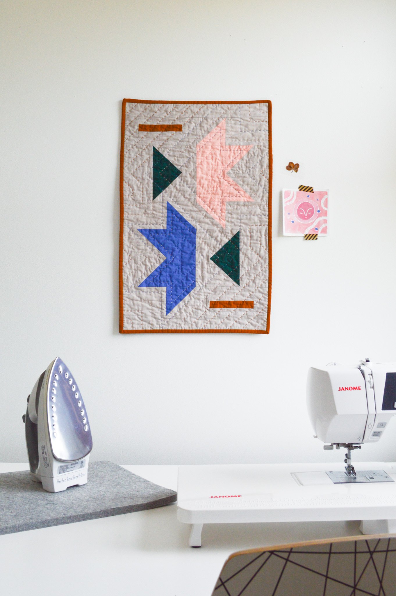  a hand quilted wall hanging on a wall in a sewing room 