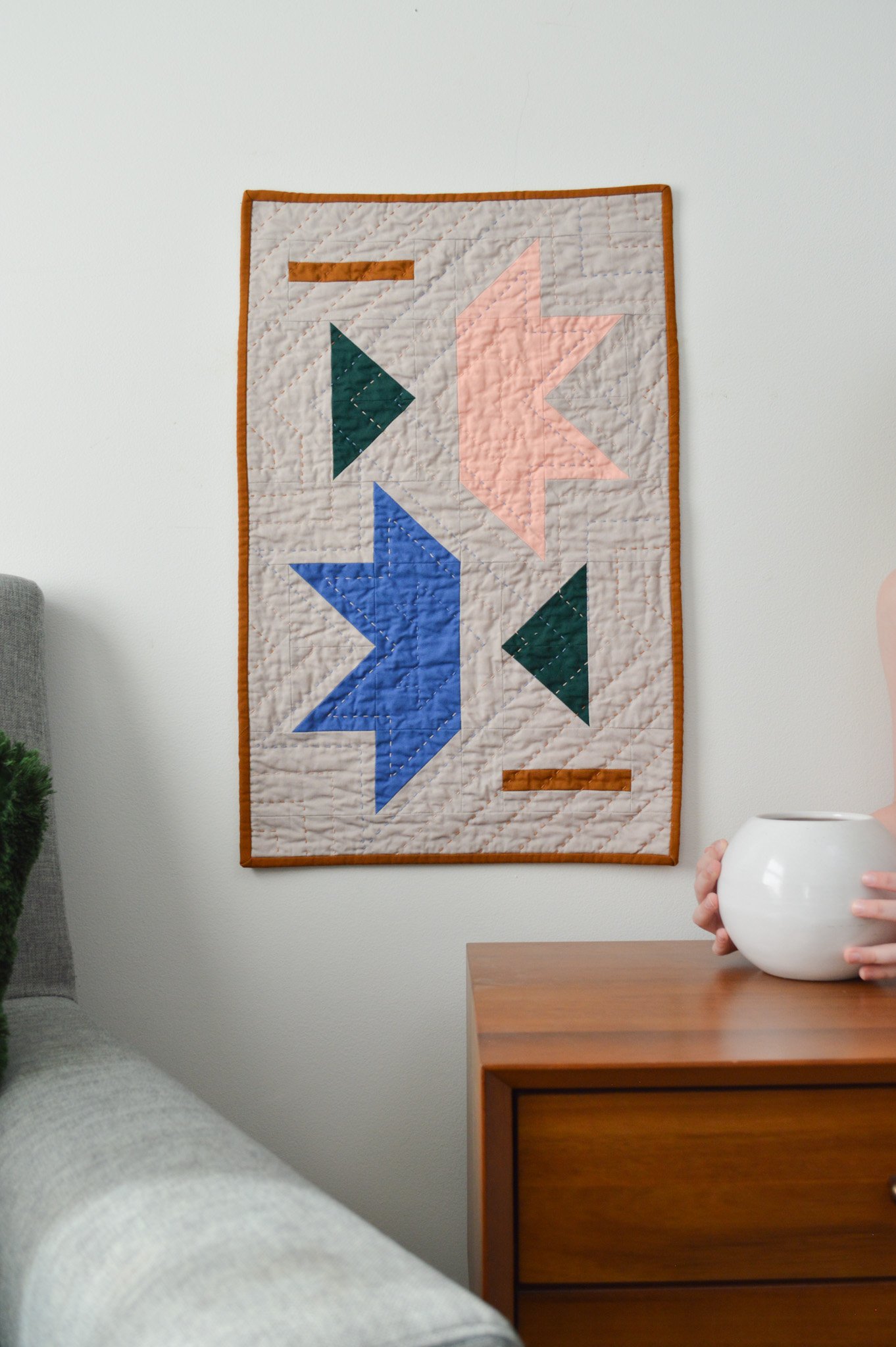  a hand quilted modern mini quilt handing on a wall 