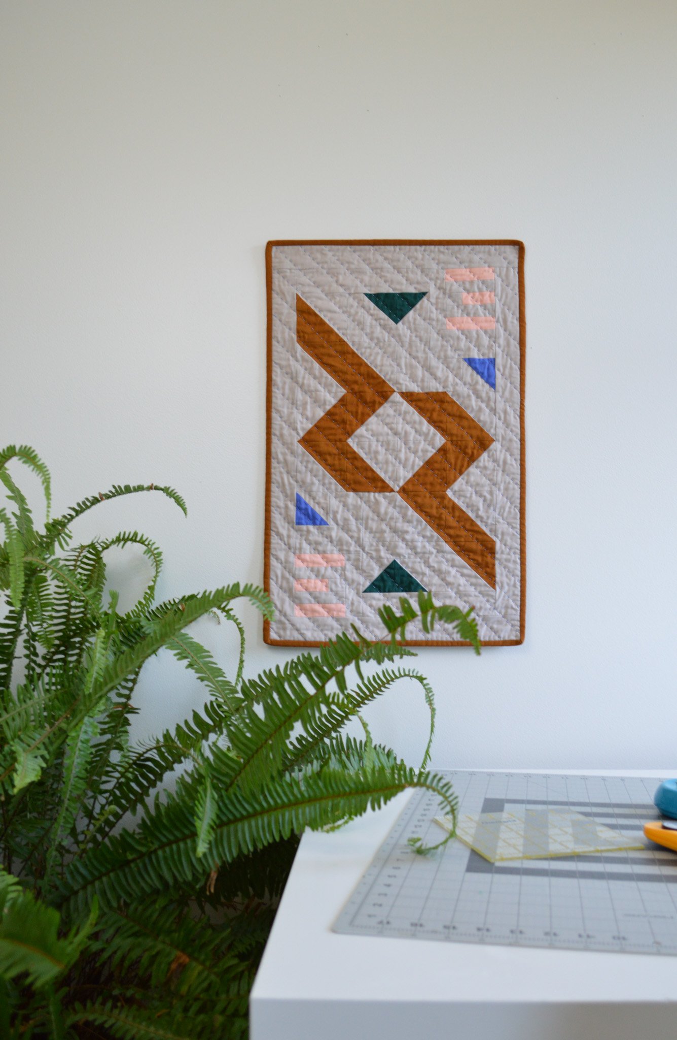  a quilted wall hanging on a wall in a sewing studio 
