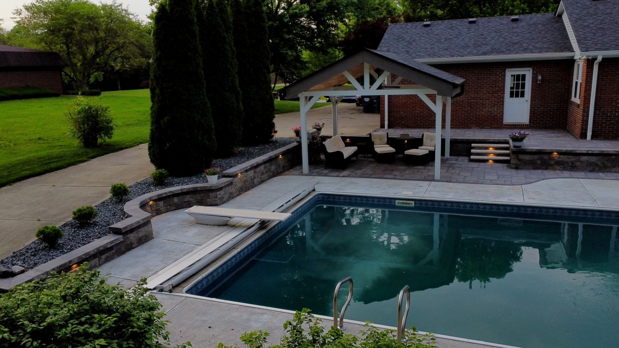 Aerial drone photography of a high-end backyard landscape design featuring curved paver walkways and geometric stone patterns by B&F Landscaping.