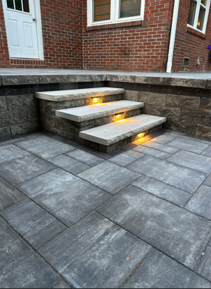 Custom stone patio steps with integrated LED riser lighting, professionally installed by B&F Landscaping in Indianapolis
