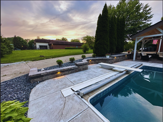 Residential pool landscape design featuring a retaining wall with integrated lighting, installed by B&F Landscaping in Indianapolis.