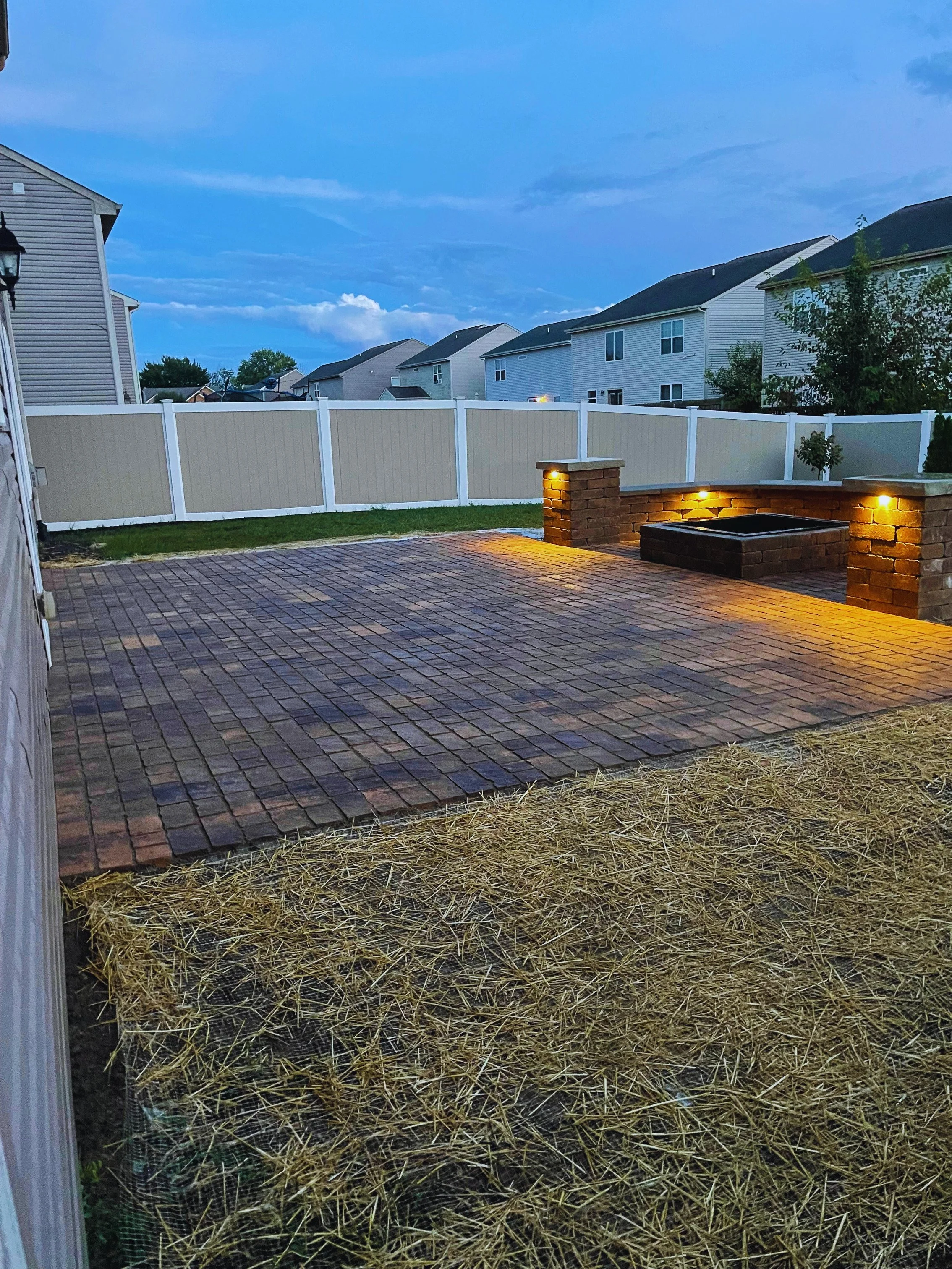 Custom paver patio design with built-in fire pit and landscape lighting, professionally installed by B&F Landscaping in Indianapolis.