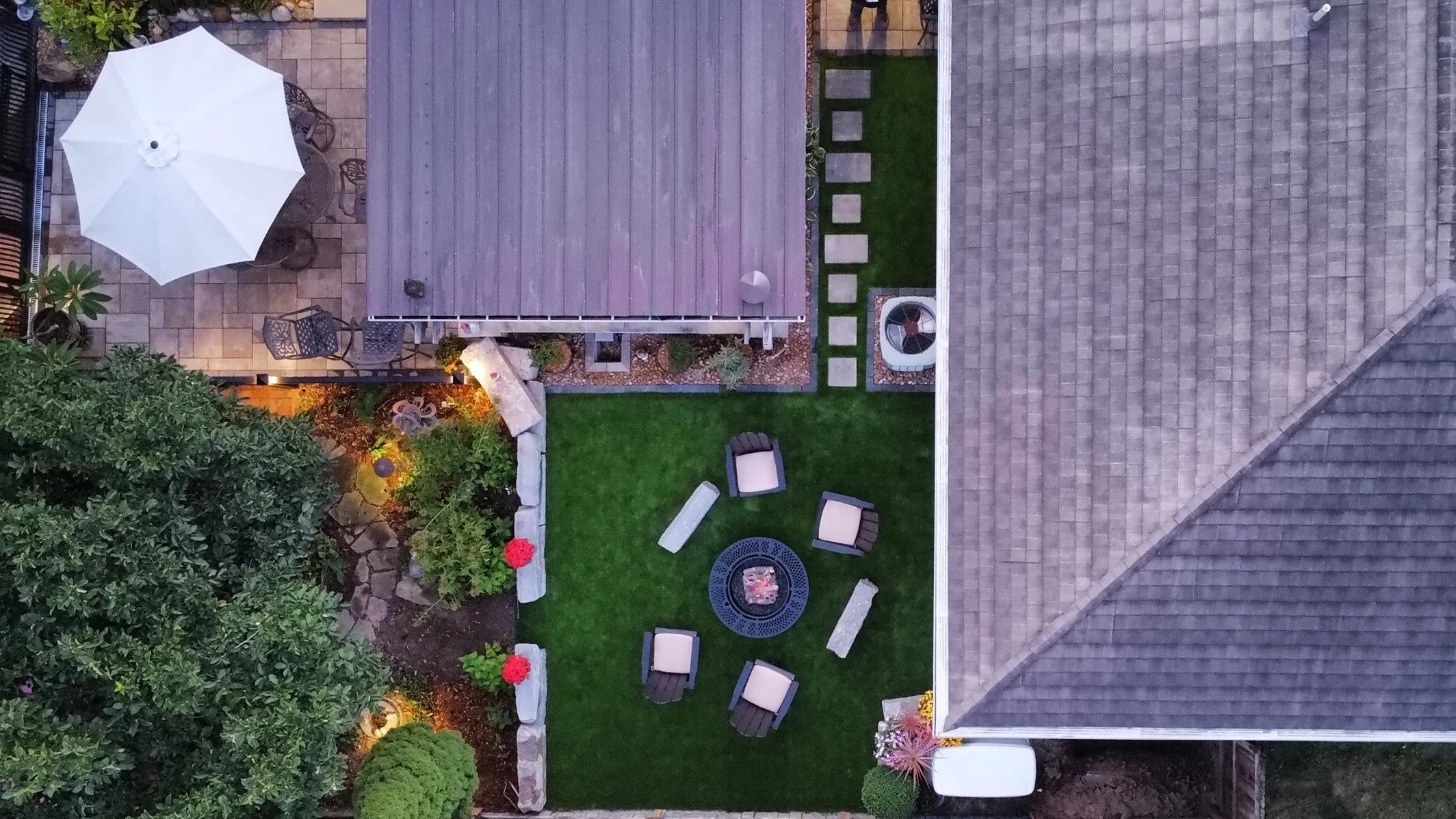 Aerial view of a residential backyard landscape design by B&F Landscaping, featuring a fire pit seating area and artificial turf in Indianapolis