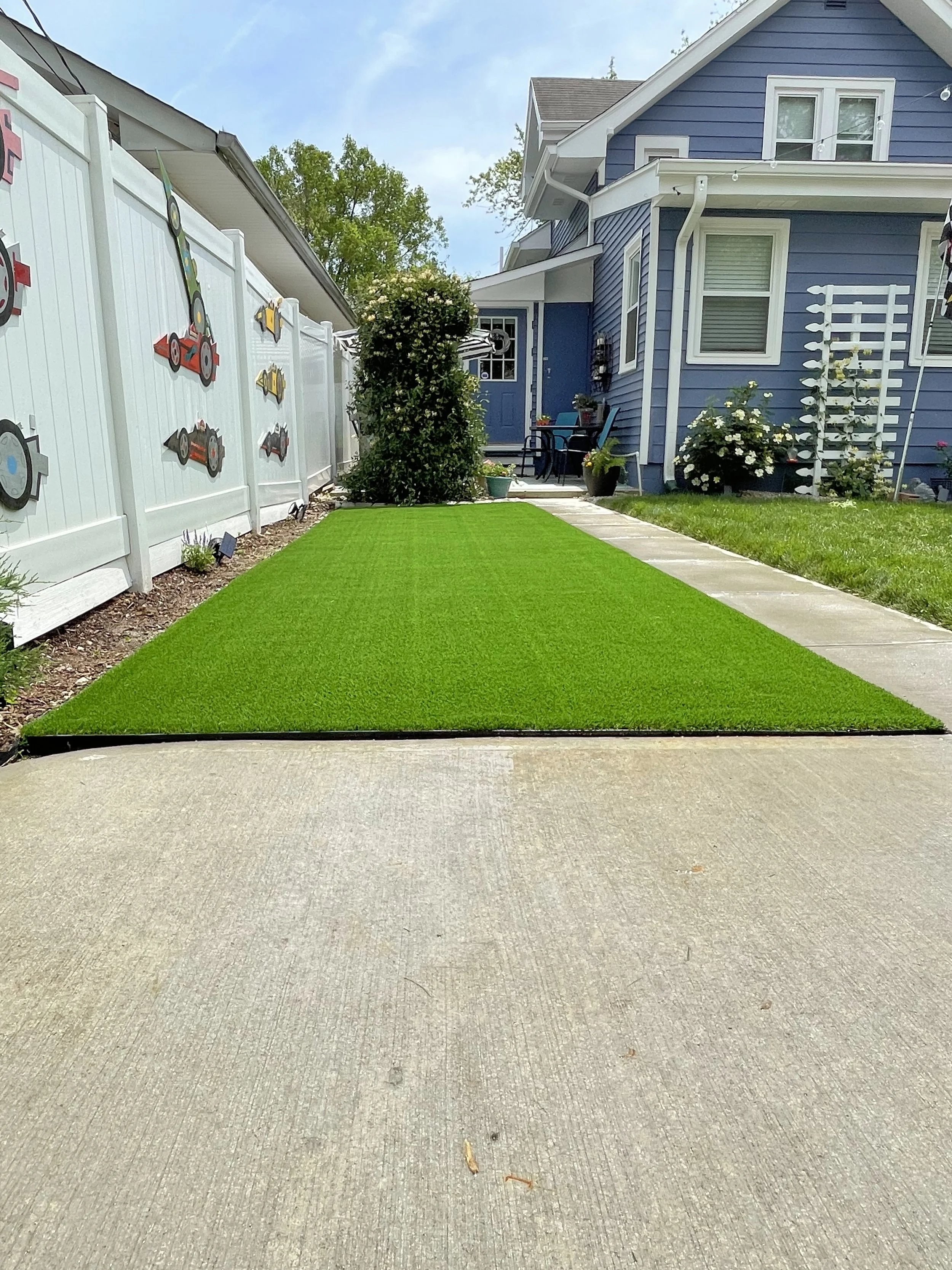 Artificial grass installation in a residential side yard, professionally completed by B&F Landscaping in Indianapolis.