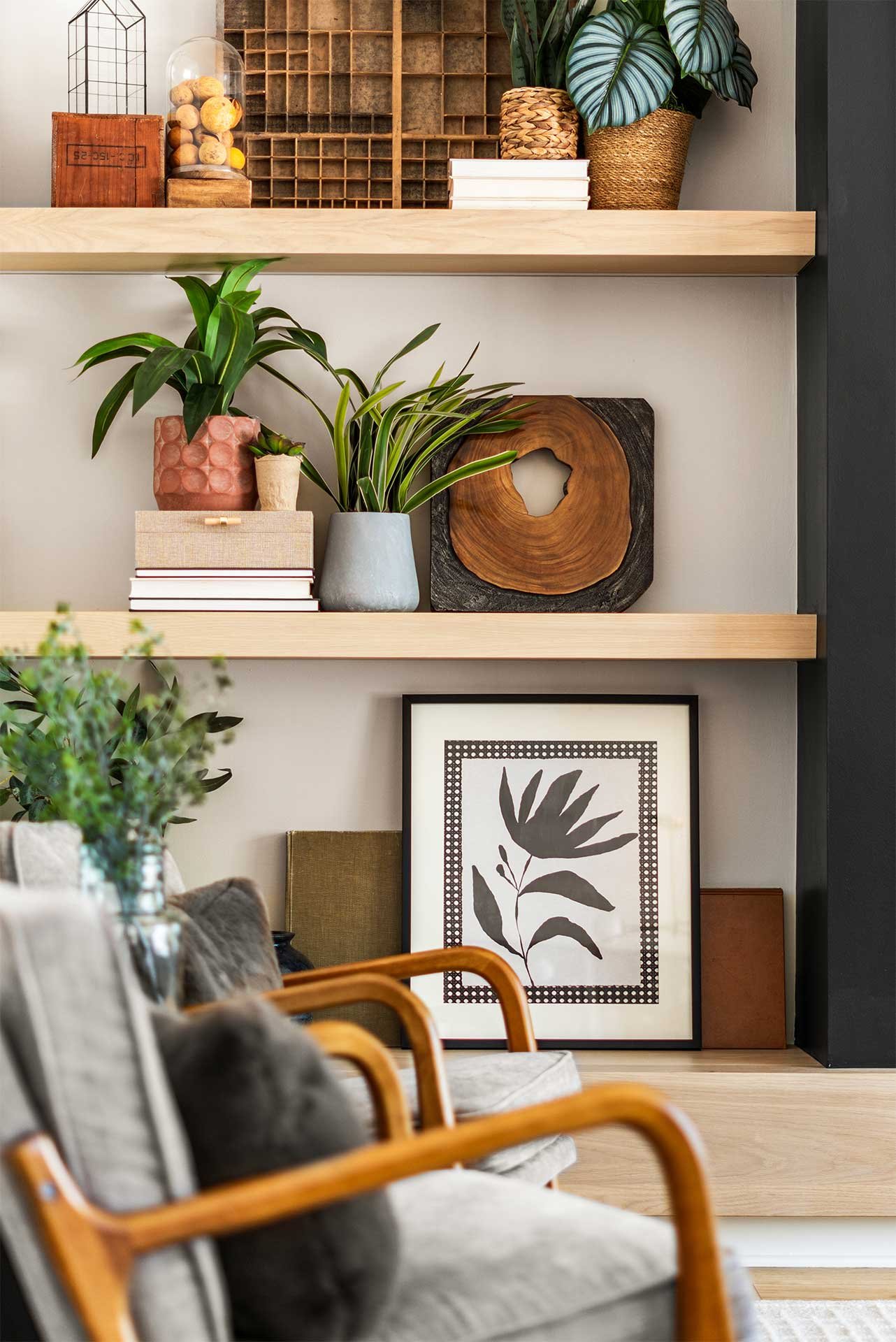 Cozy wooden shelves featuring monstera plants, pottery, books, and black-and-white botanical print by Make the Room, Interior Designers in Denver, CO.