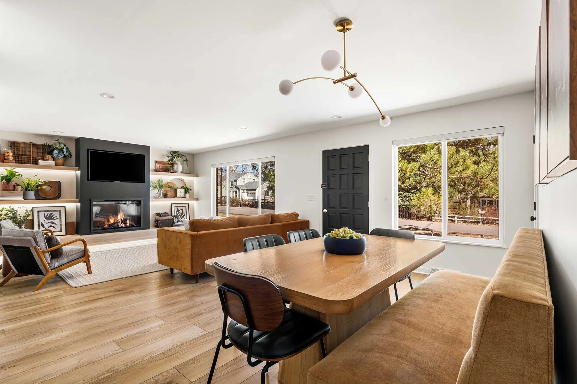 Home remodel portfolio piece with sleek wood shelves flanking statement fireplace in modern tan, black and cream interior.