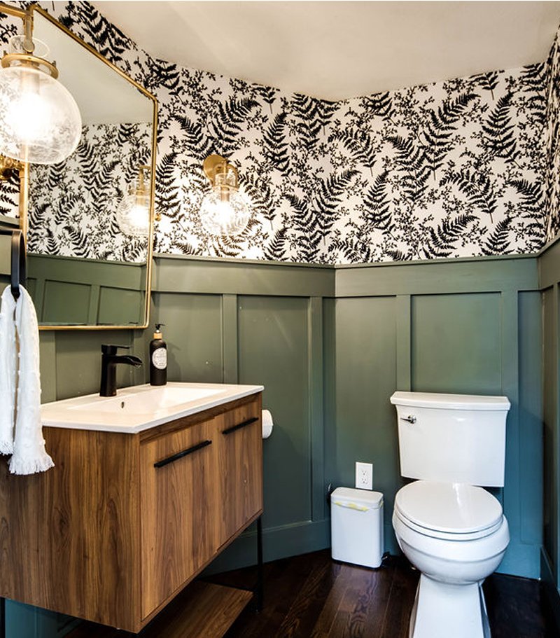 Stylish powder room with sage green shiplap, black-and-white fern wallpaper, gold accents, wood vanity, and toilet, exemplifying interior design services from Make The Room