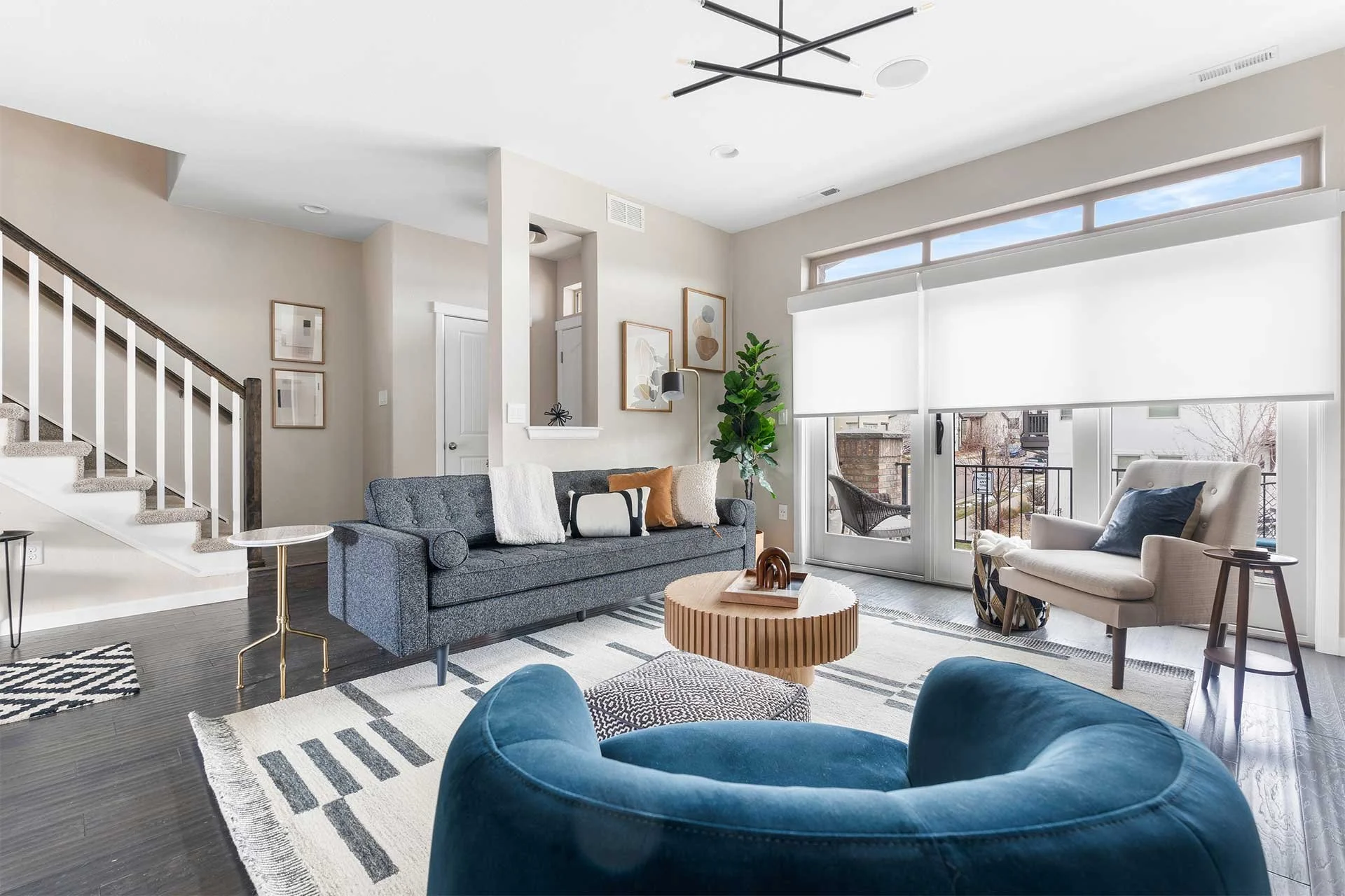 Modern living room design with barrel chair, couch, coffee table, and tall plant.