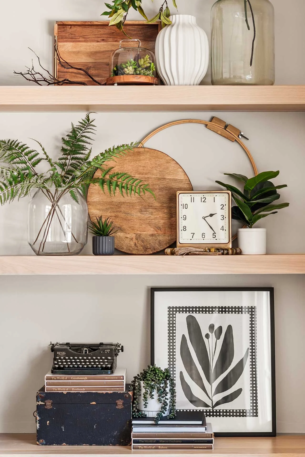 Light wood shelves with clock, glass vases, wood accents in home remodel design in Denver.