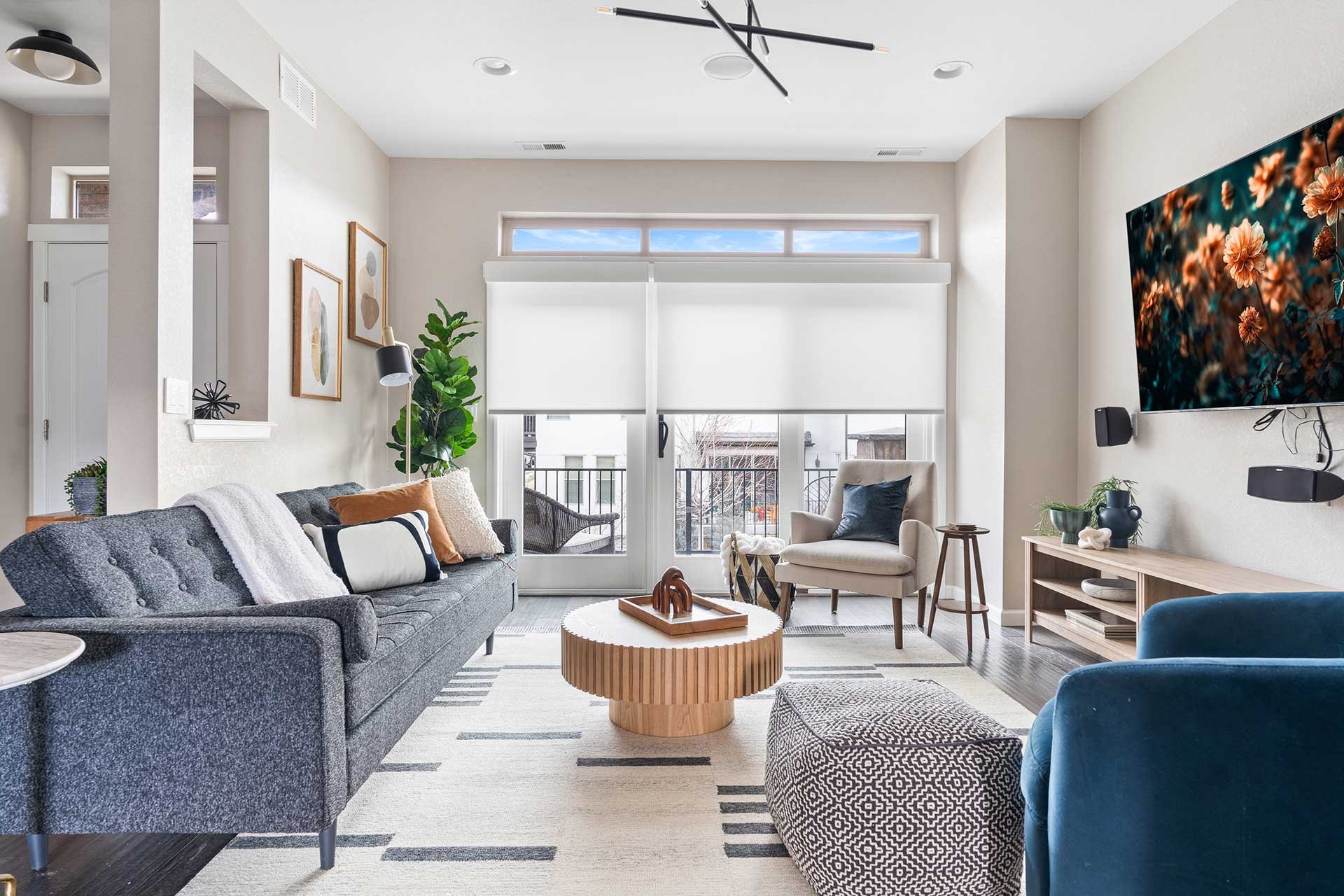 Modern living space design with a sofa, arm chair, barrel chair, coffee table and media console.