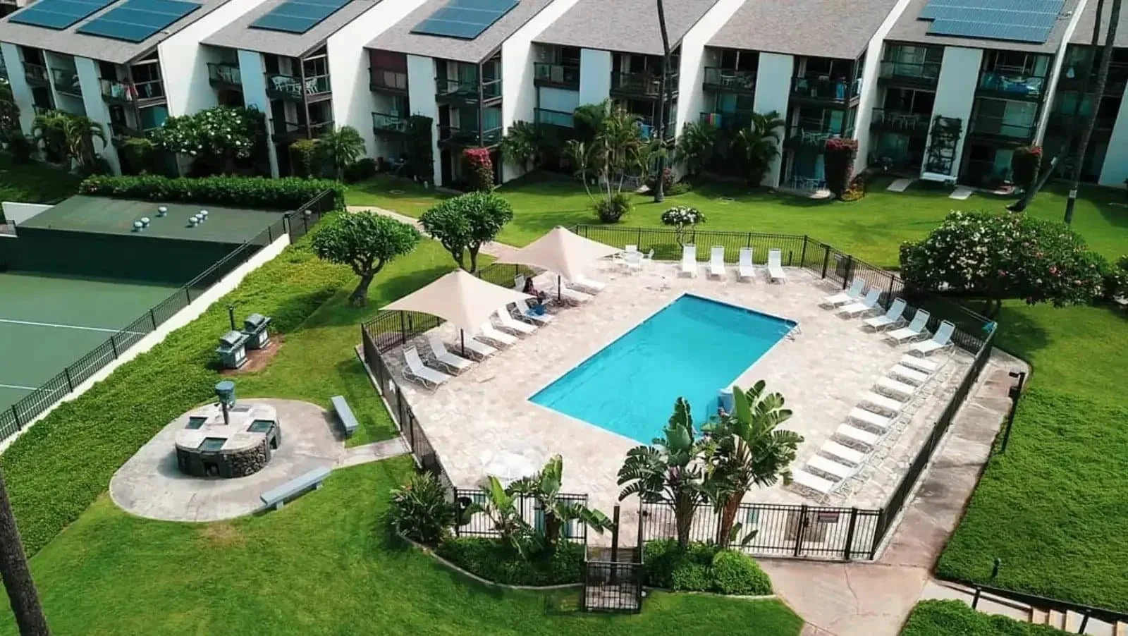 Aerial view of Hale Kamaole vacation rentals in Kihei, Maui with swimming pool, pickleball court and tropical grounds