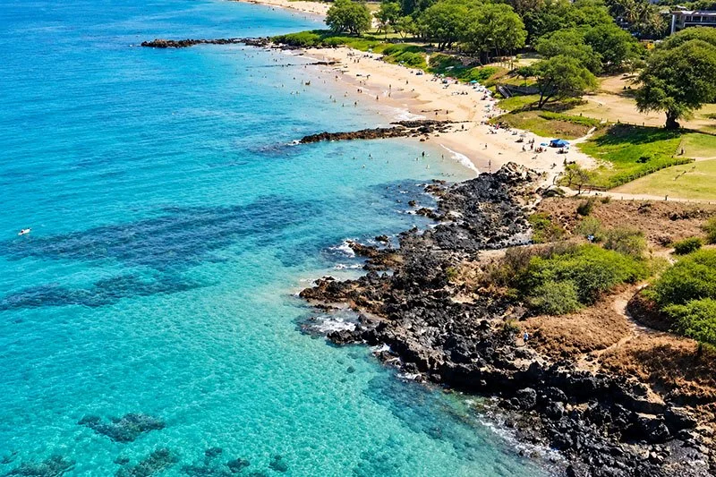 Aerial view of Kamaole Beach Park III in South Kihei, Maui with turquoise water, sandy beach and rocky shoreline