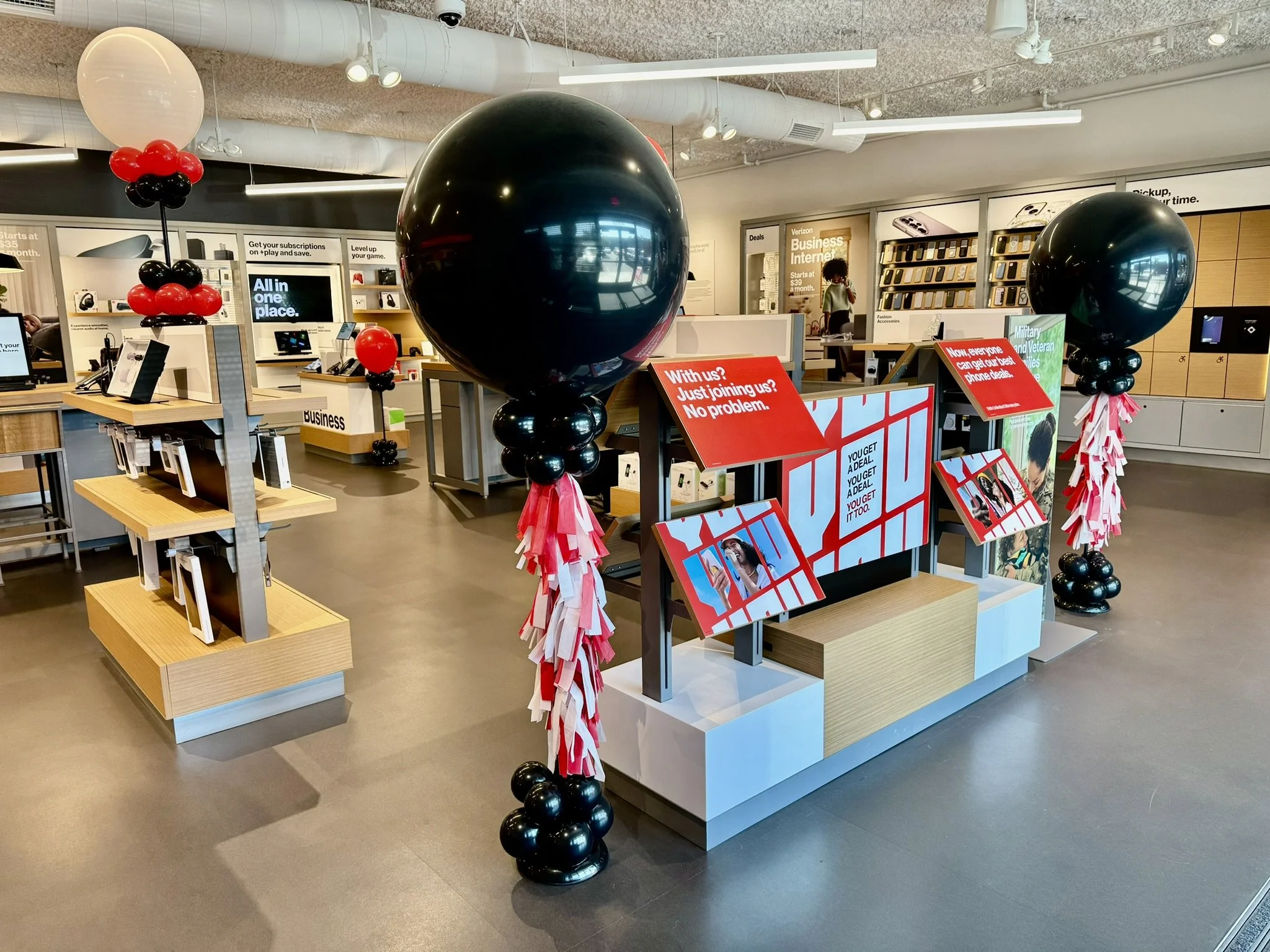 Custom balloon decorations for business grand opening event inside Tacoma, WA store with black, red, and white balloons.
