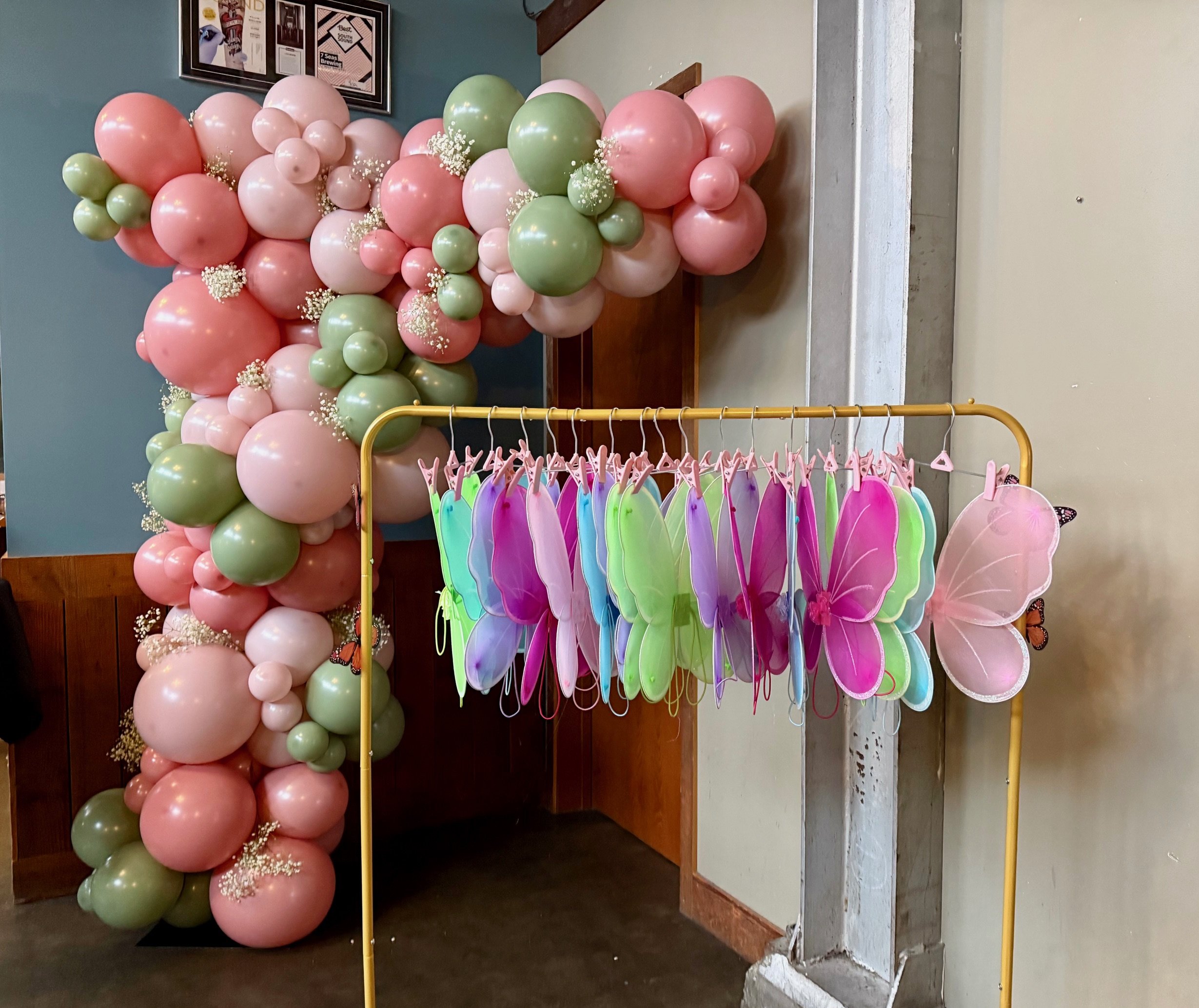 Rose pink and green balloon garland for whimsical butterfly kids birthday party decorations