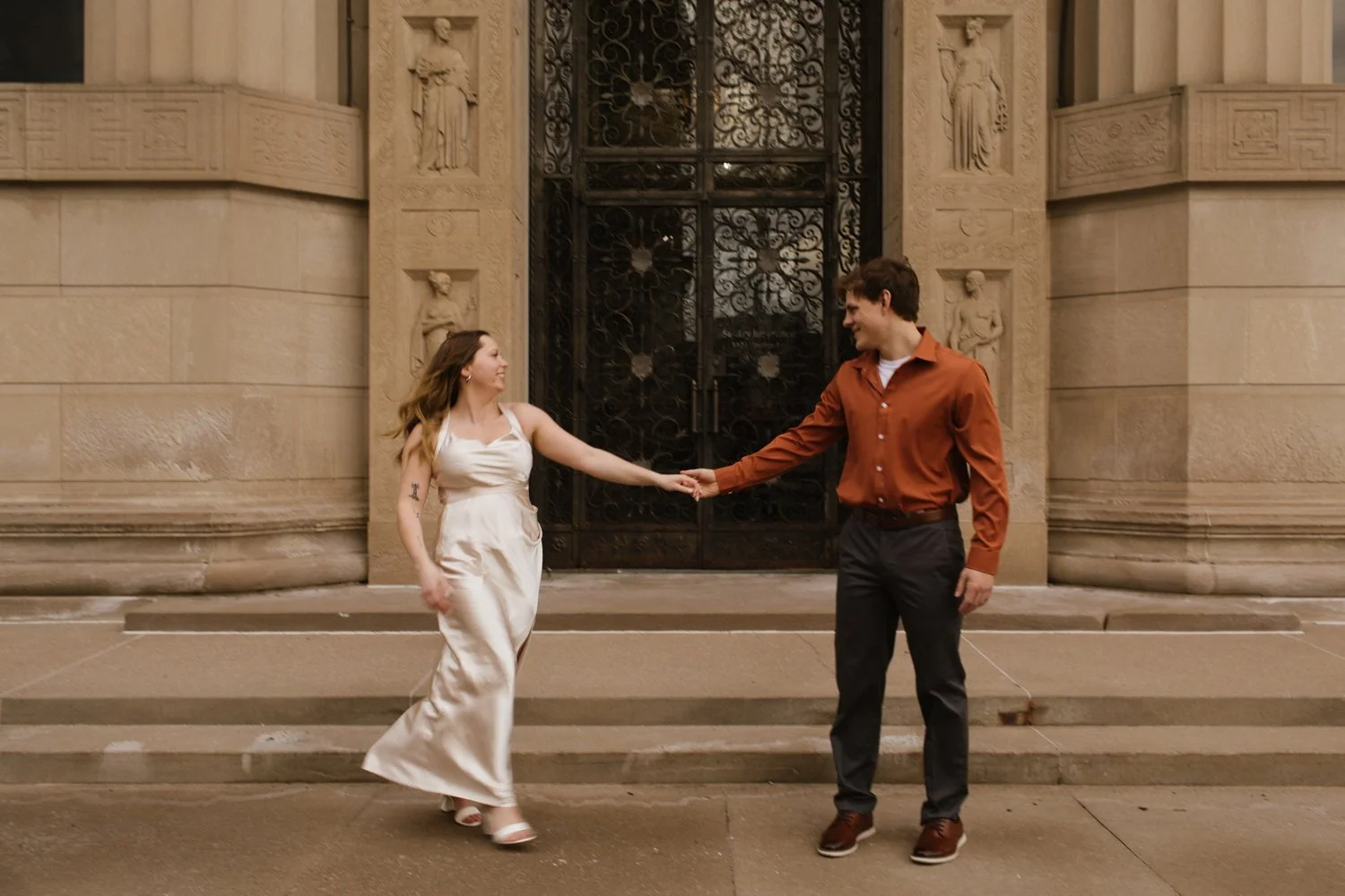 man and woman dance engagement session in front of sentry insurance building in downtown stevens point wisconsin