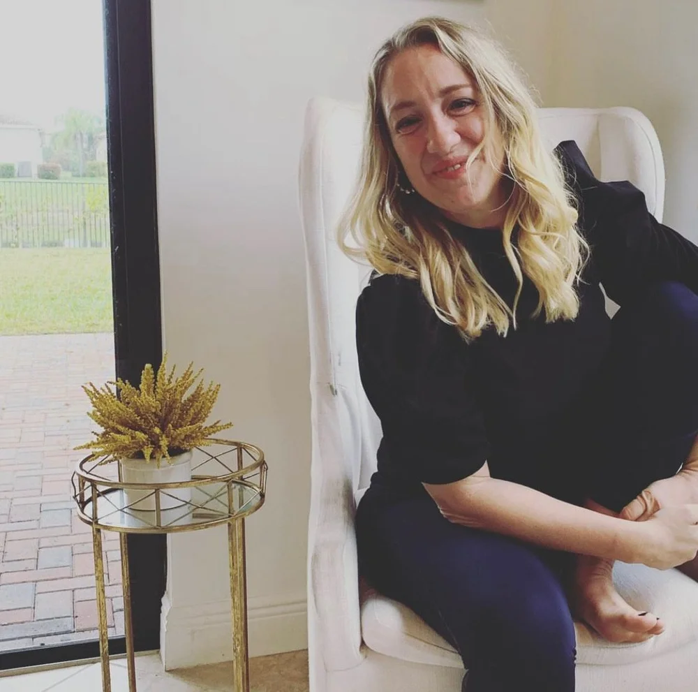 Kristin smiling in a white chair