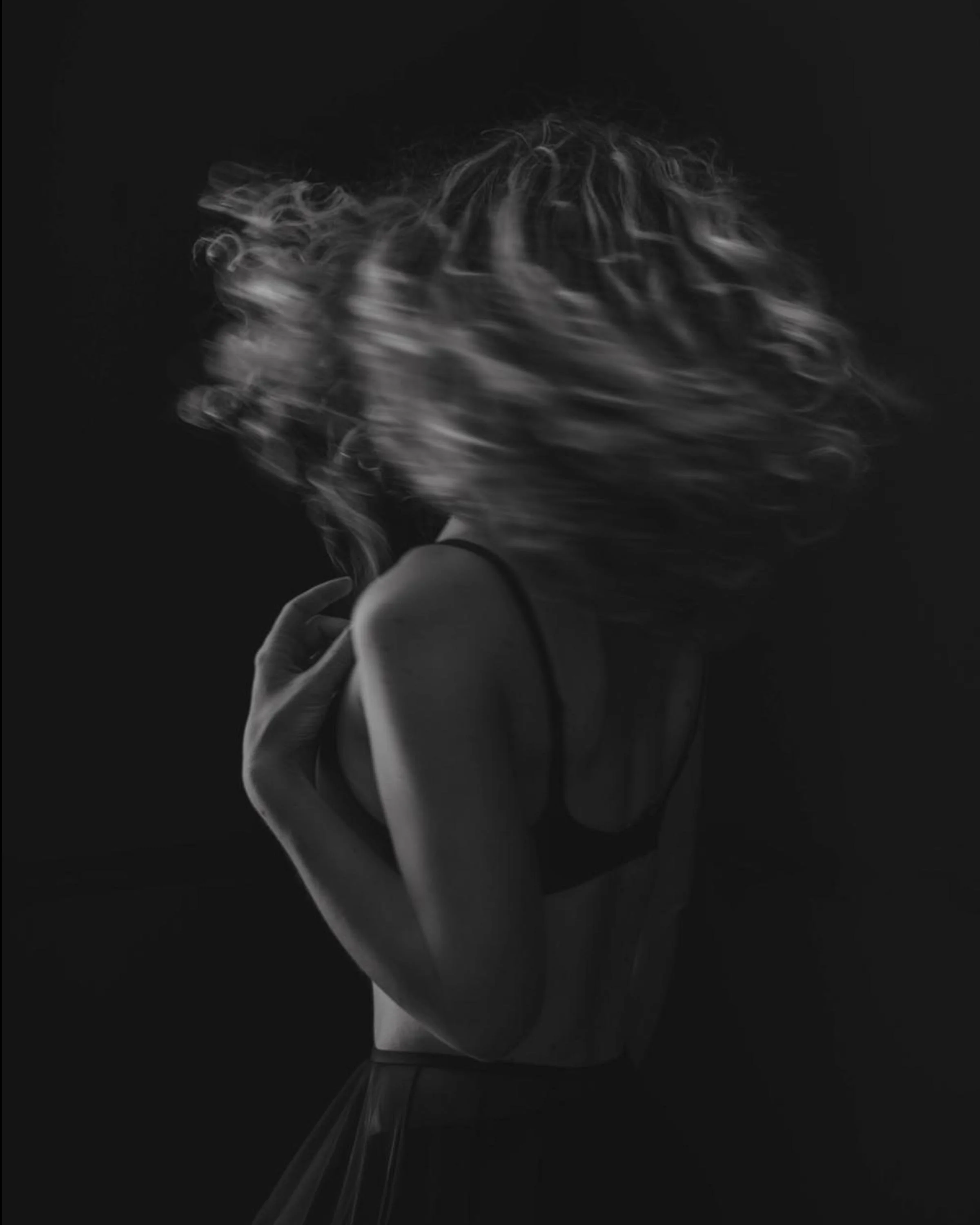 Creative portrait photography capturing movement and artistic expression with dramatic hair motion blur