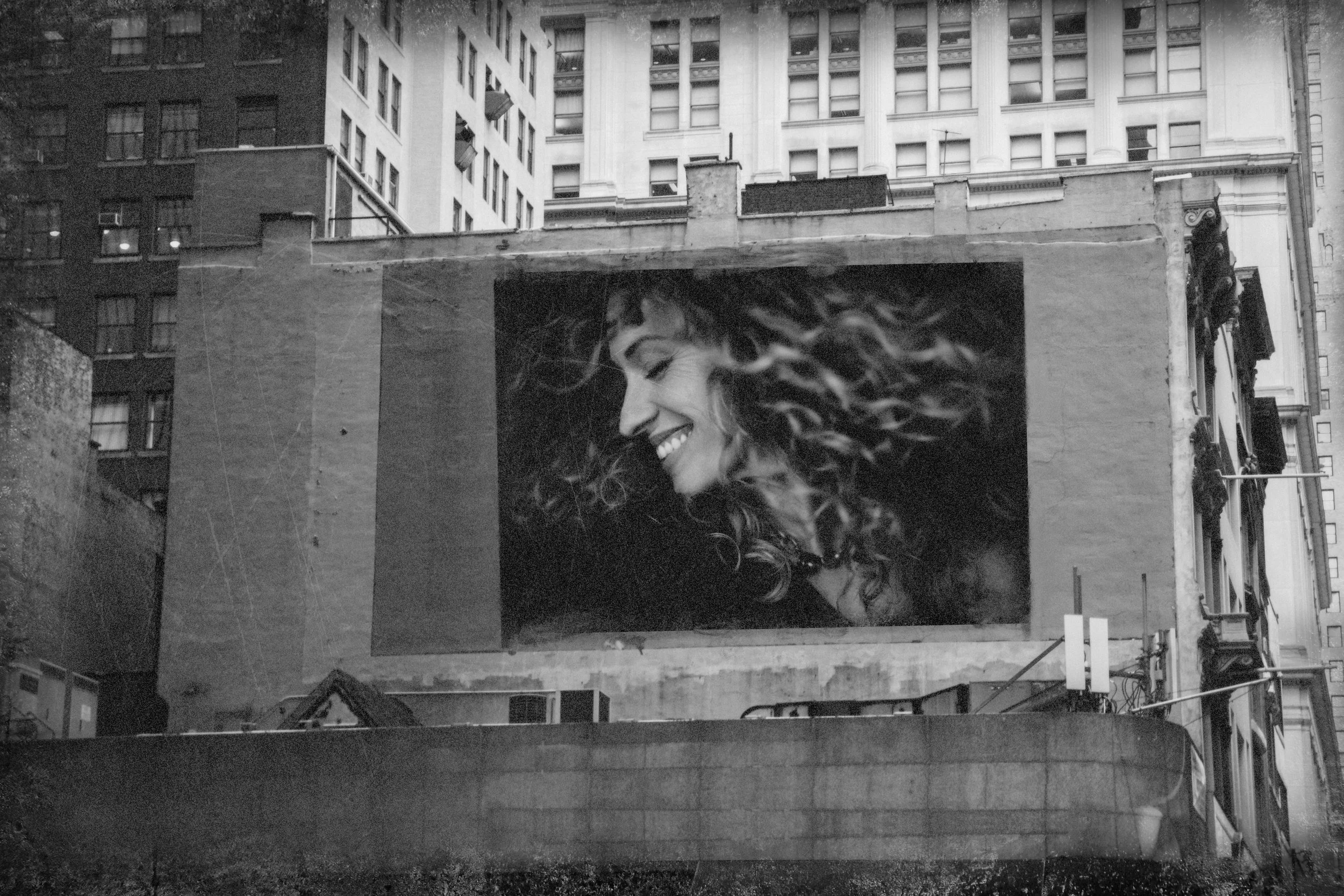 fine art black and white portrait of a woman displayed on a city billboard