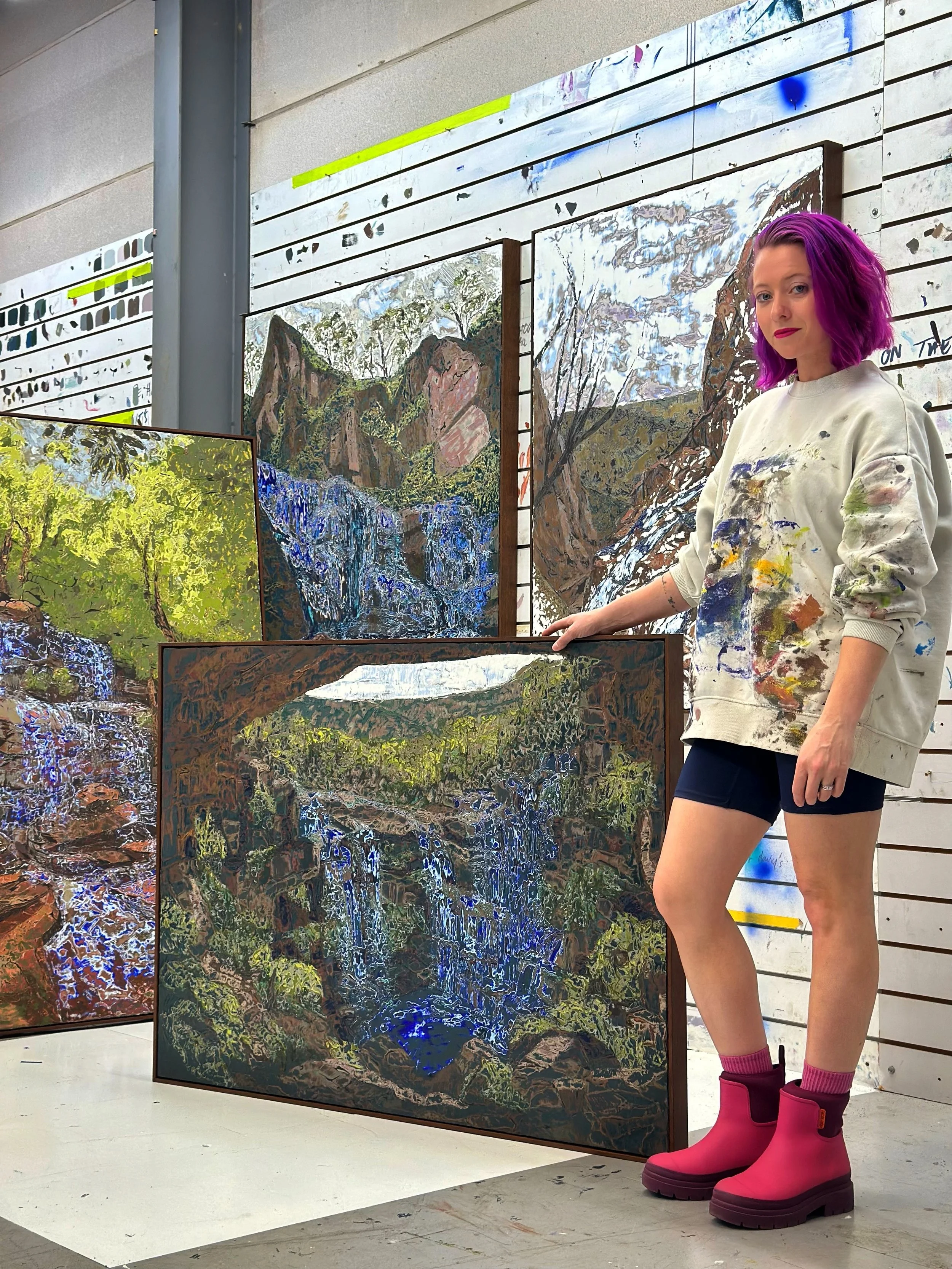 Korynn Morrison in her studio beside four new Excavated Landscapes paintings of waterfalls and mountains, ahead of Art Toronto 2026 with Galerie C.O.A
