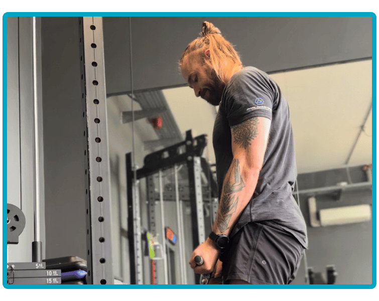 Owner of JJ strength, Jamie, performing cable bicep curl exercise