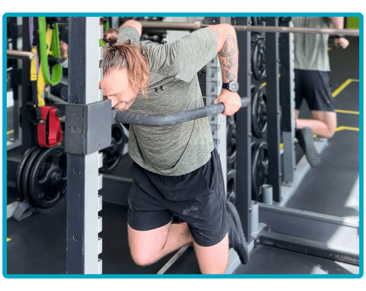 Jamie, owner of JJ Strength, performing a dip bar exercise in the gym