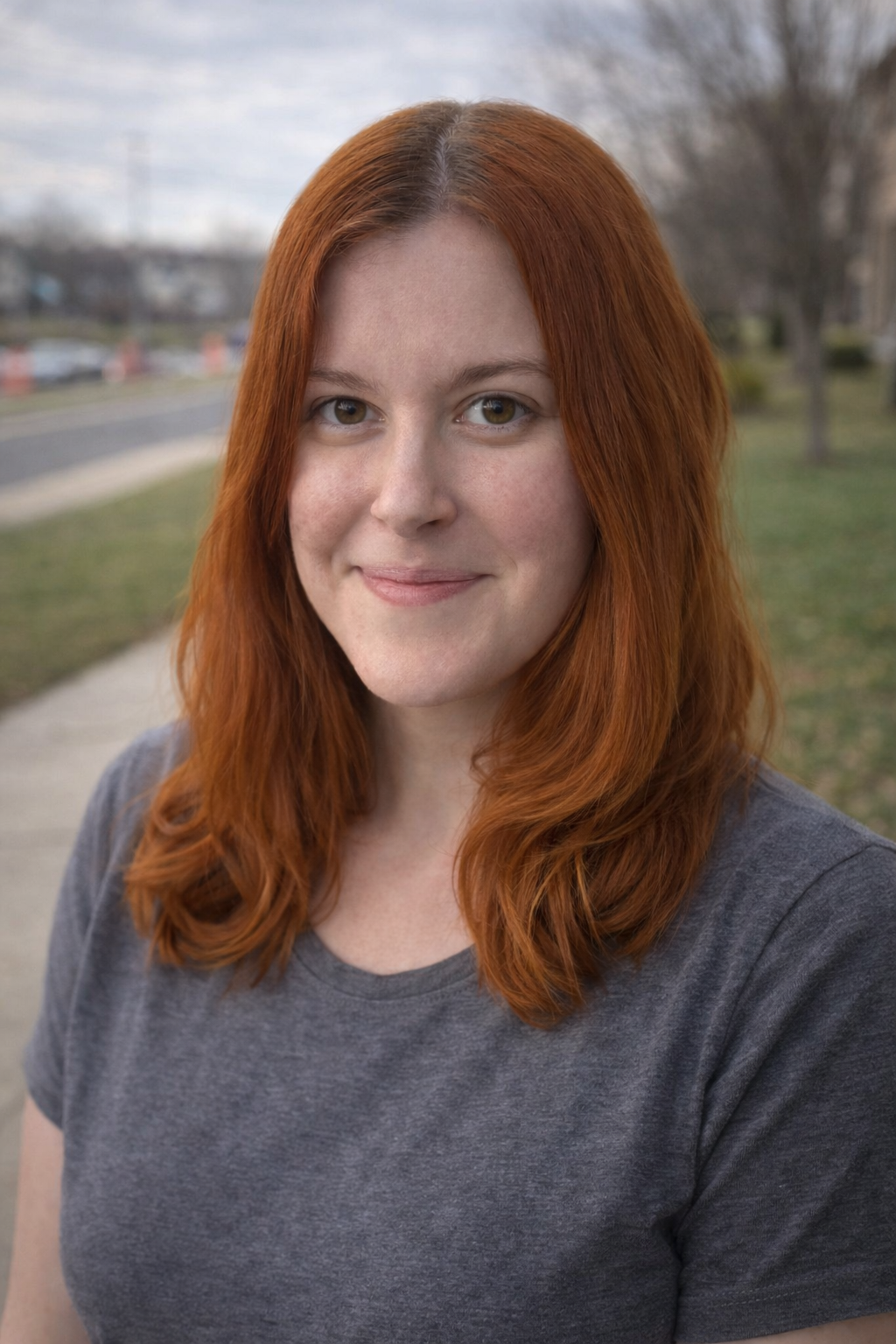 red head girl smiling at the camera outside
