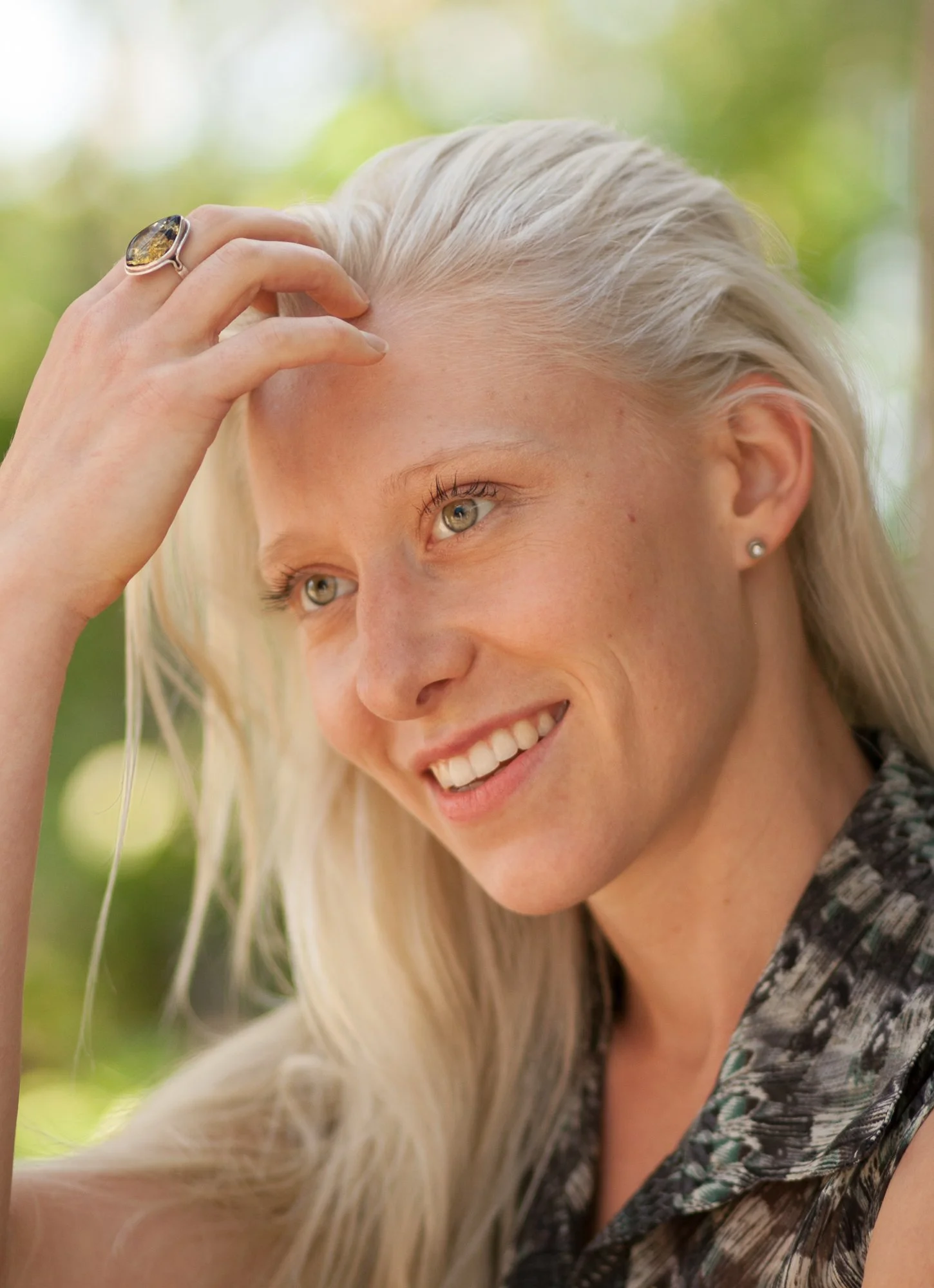 Jillian sourit en passant sa main dans ses longs cheveux blonds. Elle porte une grosse bague à cette main qui brille au soleil.