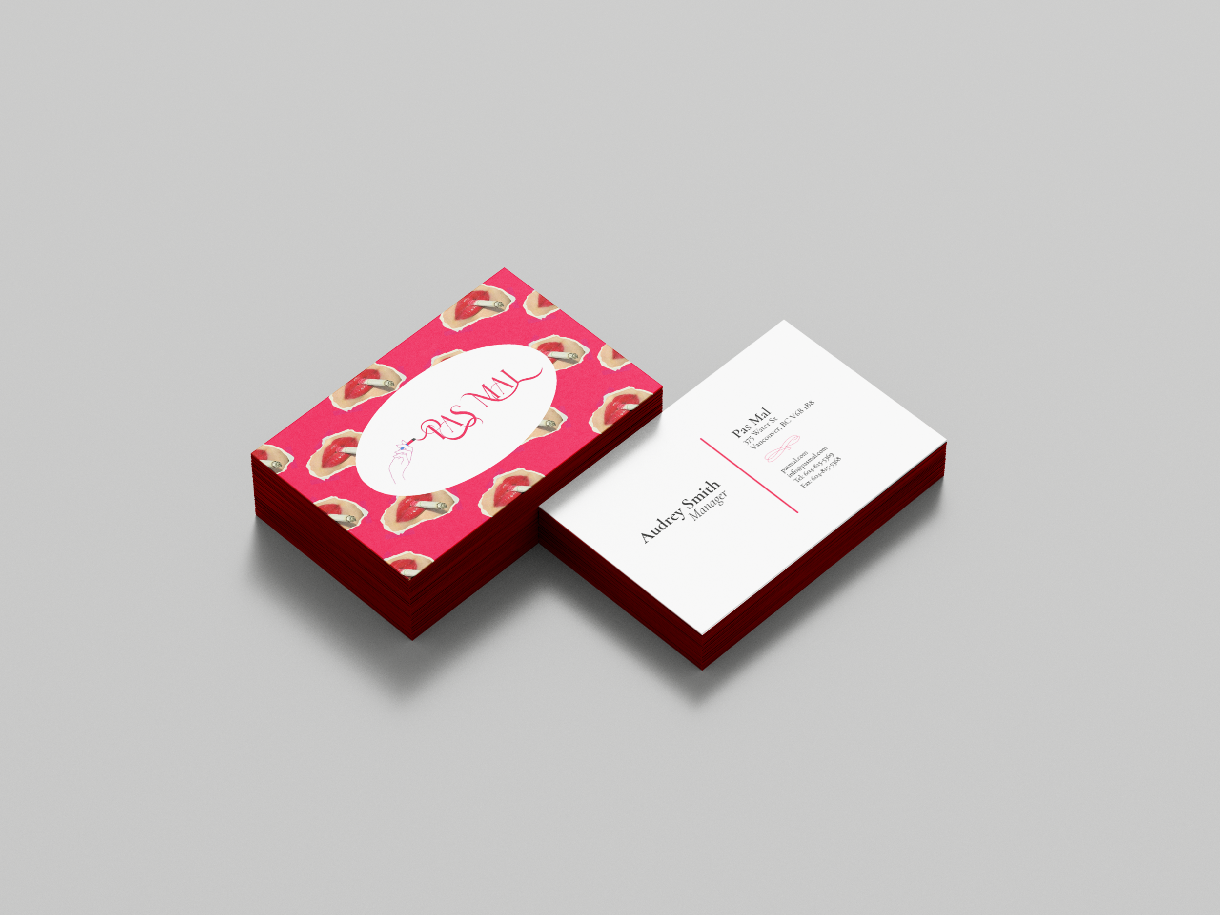 Front and back of a business card displayed. The front says "Pas Mal," the words eminating from an illustration of a hand holding a cigarette.