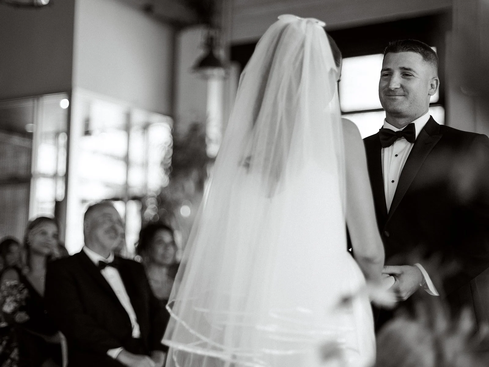 groom smiling at bride as they stand at the wedding altar at Battello